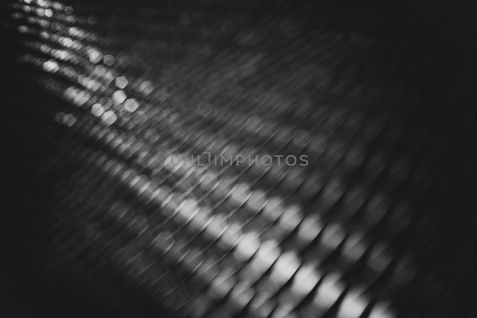 Black and white coarse bokeh on the metallic grill, out of focus