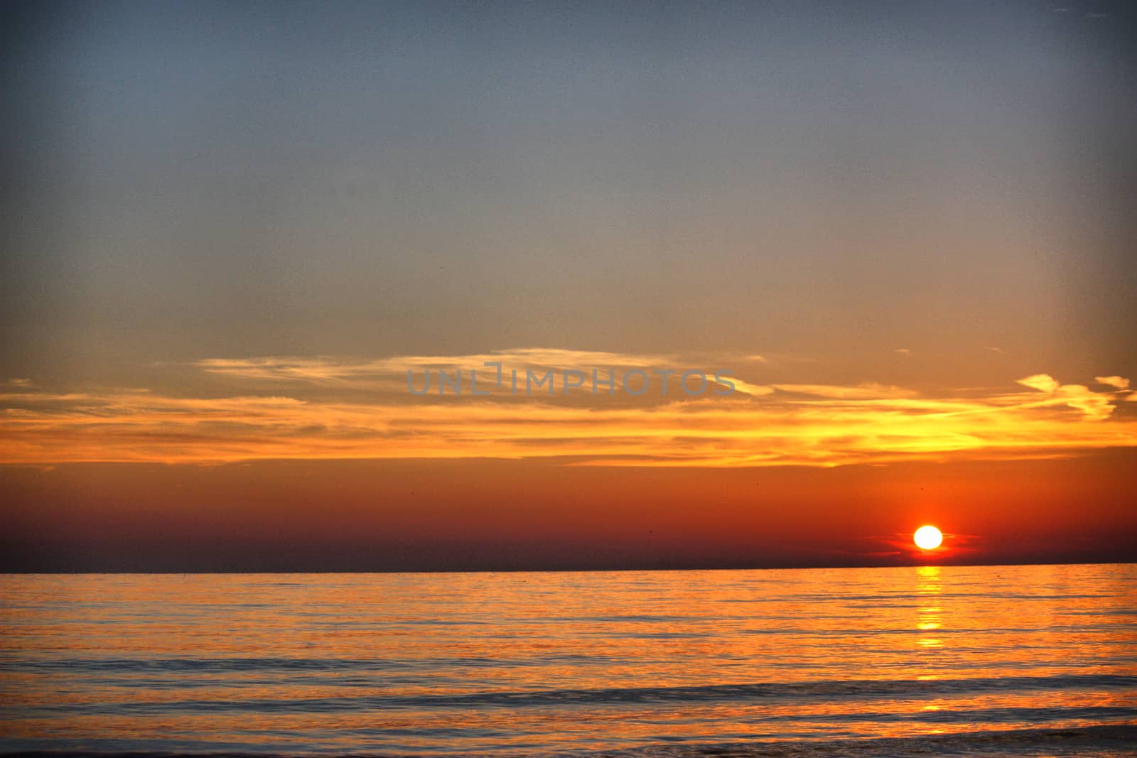 Beautiful sunset over a quiet calm ocean by chrisga