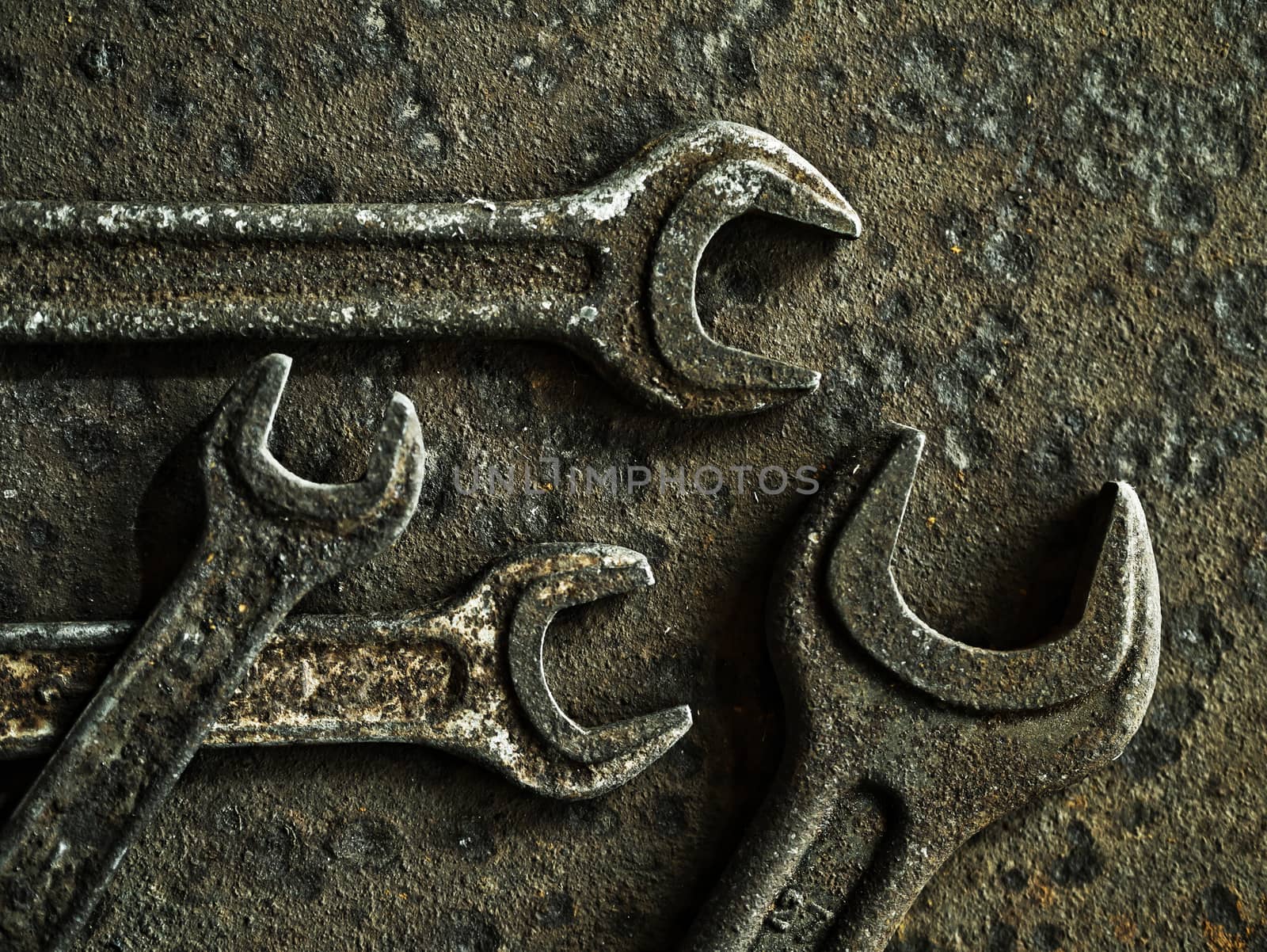 Old wrenches on a rusty metal background