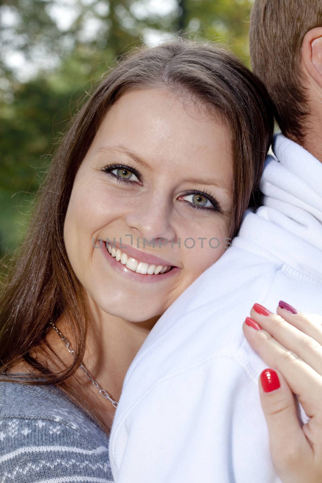 happy young girl embracing her boyfriend, smiling by courtyardpix