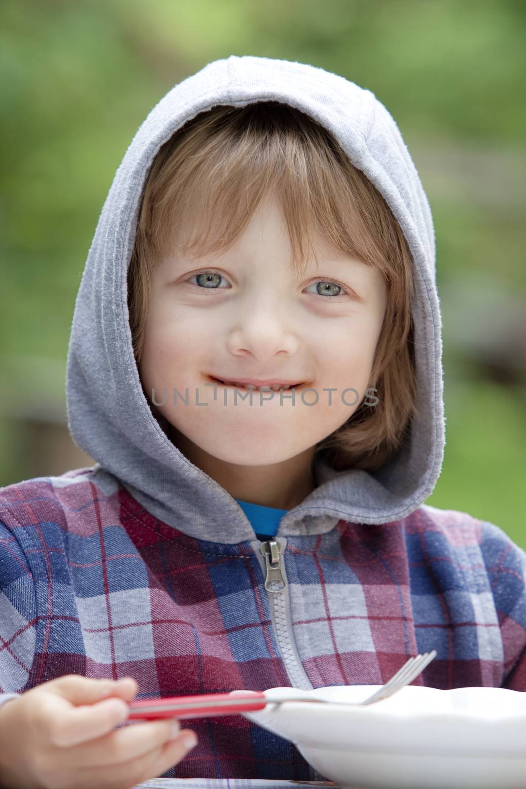 Boy with Blond Hair in Hood Eating Pasta