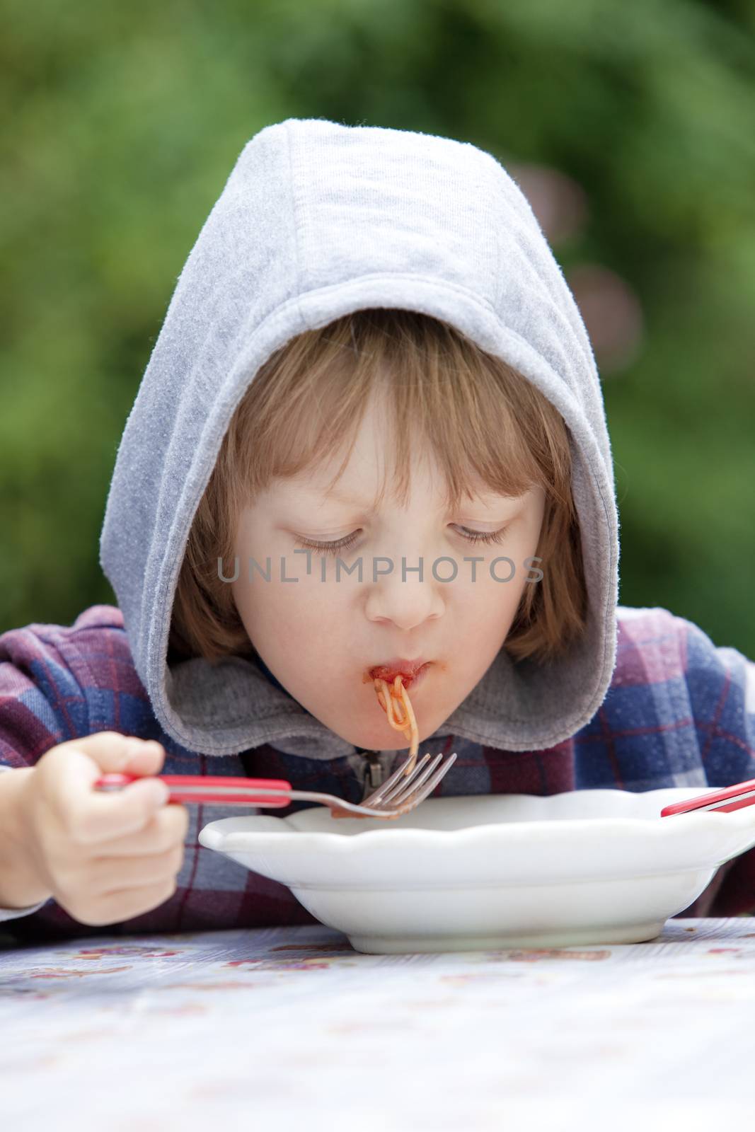Boy with Blond Hair in Hood Eating Pasta