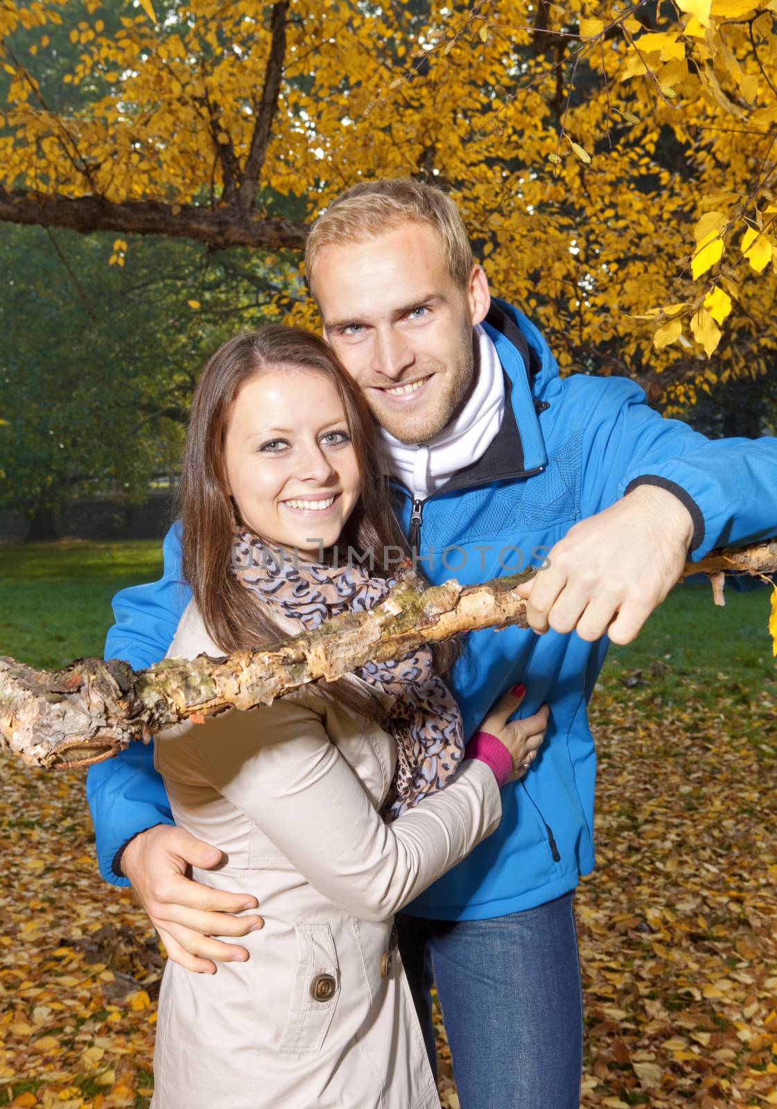 portrait of a happy young couple in the park, embracing, smiling.