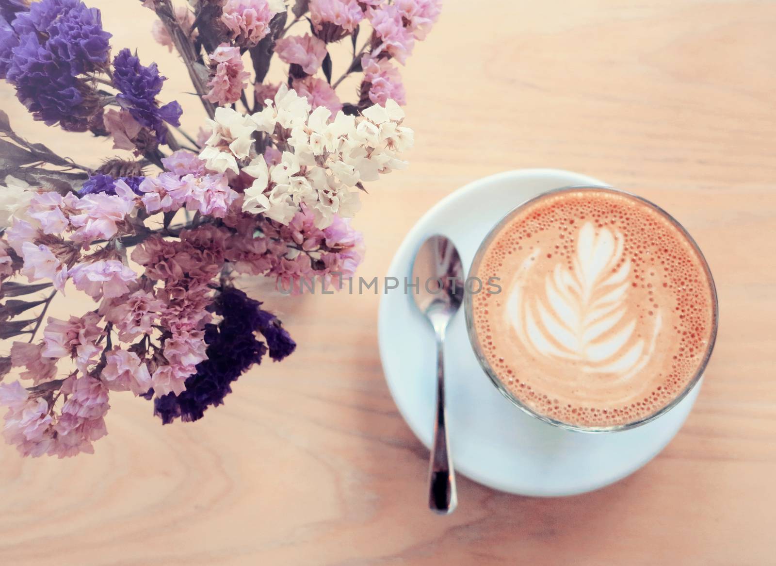 Cup of latte or cappuccino coffee and flowers with retro filter effect                            