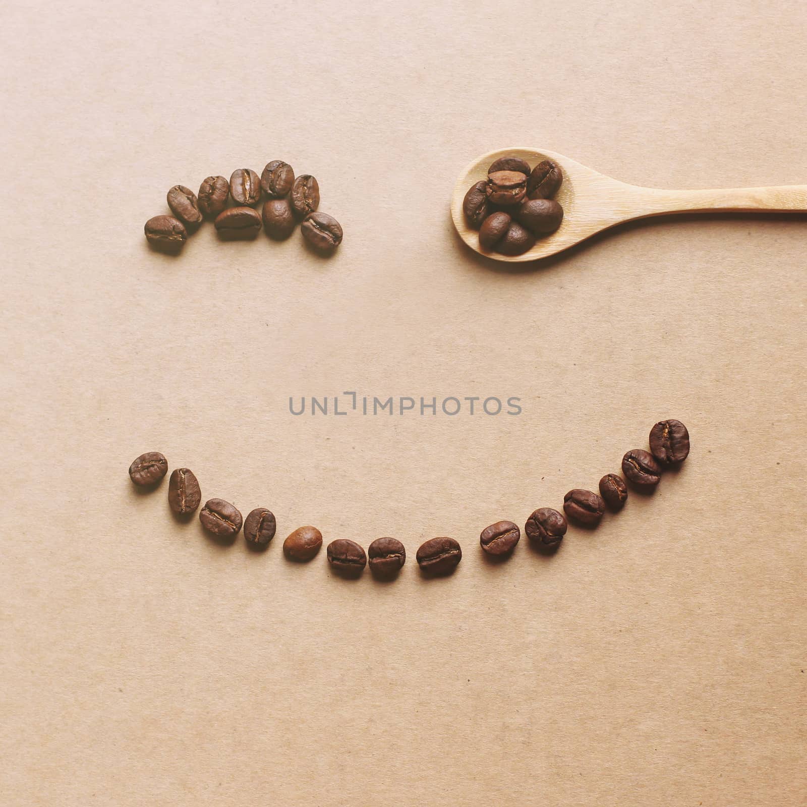 Happy face shaped of coffee beans with wooden spoon, retro filter effect
