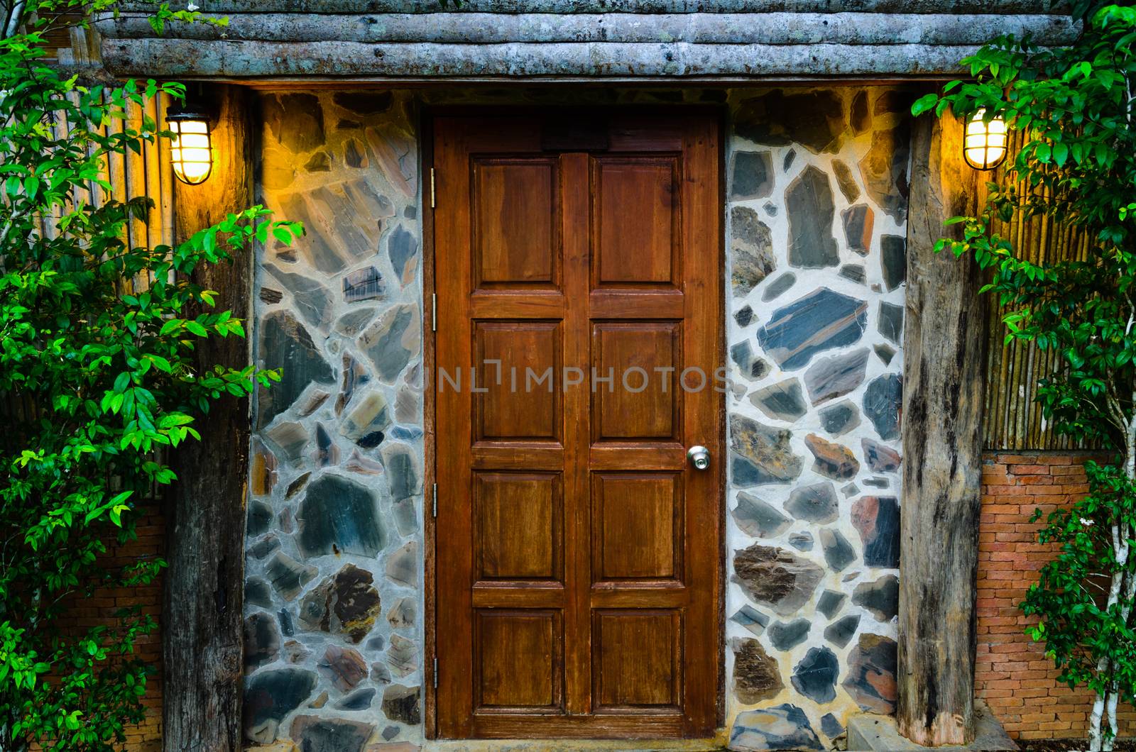 Front wooden door of residence, surrounded by nature in evening