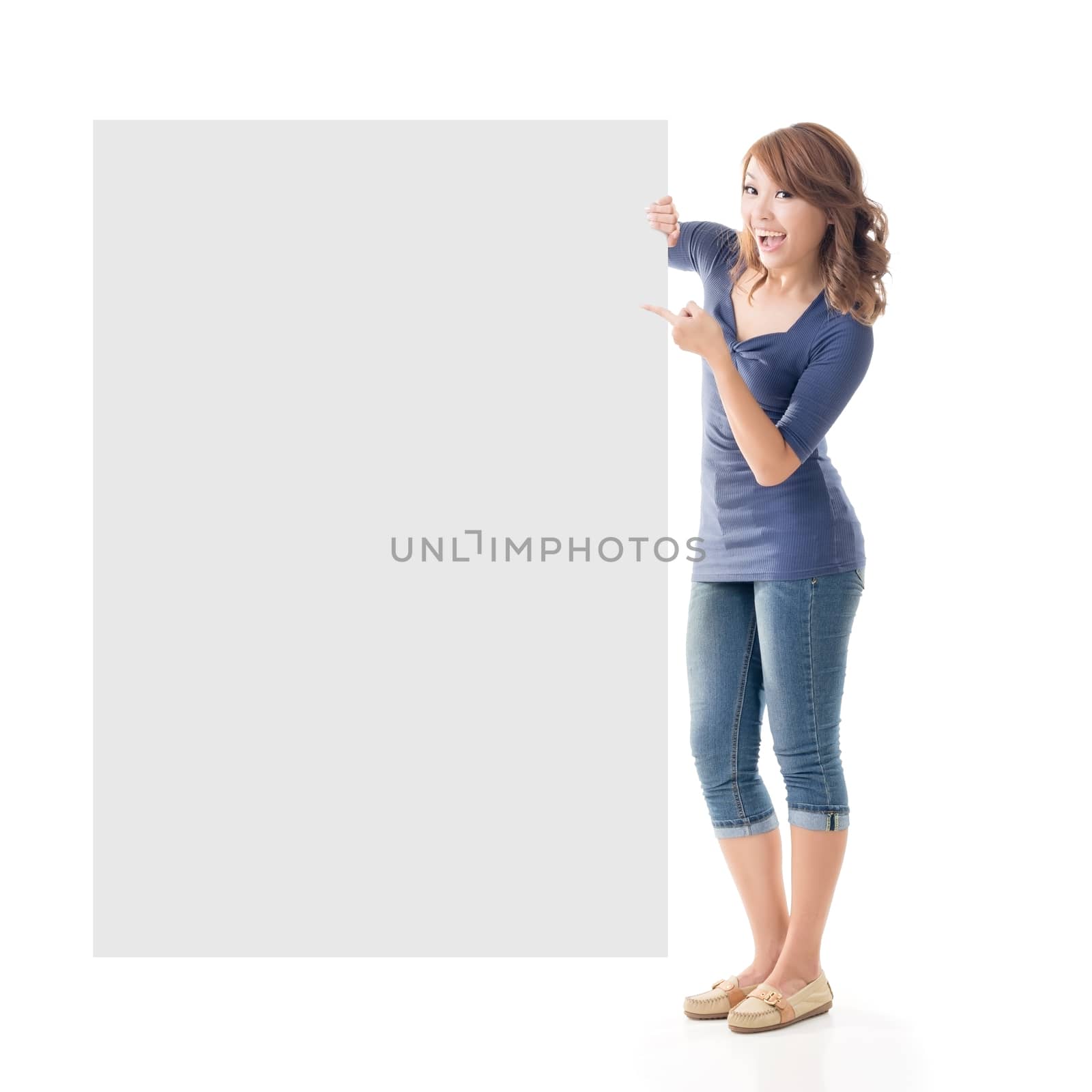 Excited Asian girl hold a blank board, full length portrait isolated on white.