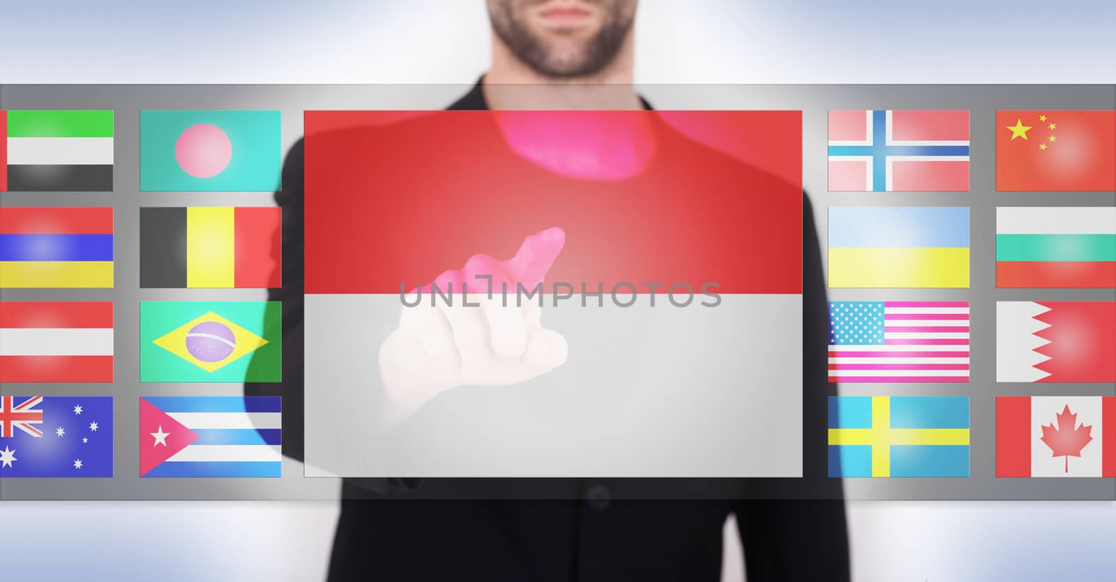 Hand pushing on a touch screen interface, choosing language or country, Indonesia