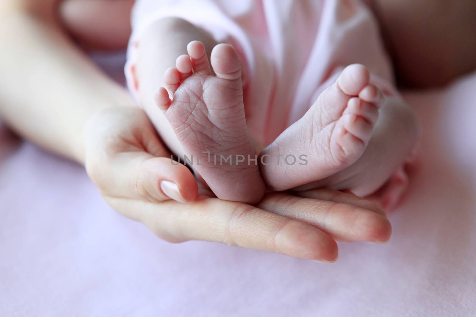 Parent hand hold baby girl legs