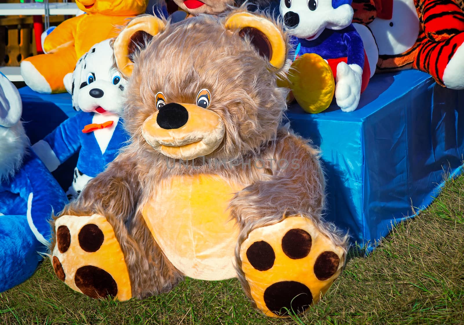 For sale at fair toys for children are presented: big amusing teddy bear and other toy animals.