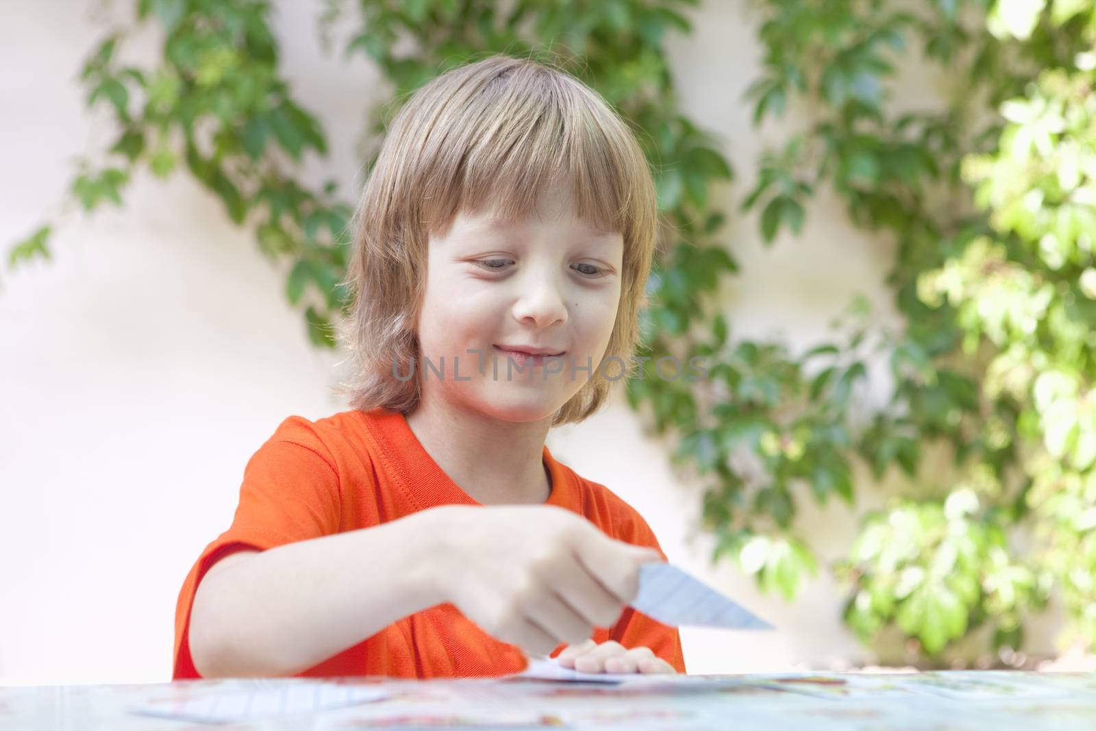 Boy with Blond Hair Playing Cards by courtyardpix