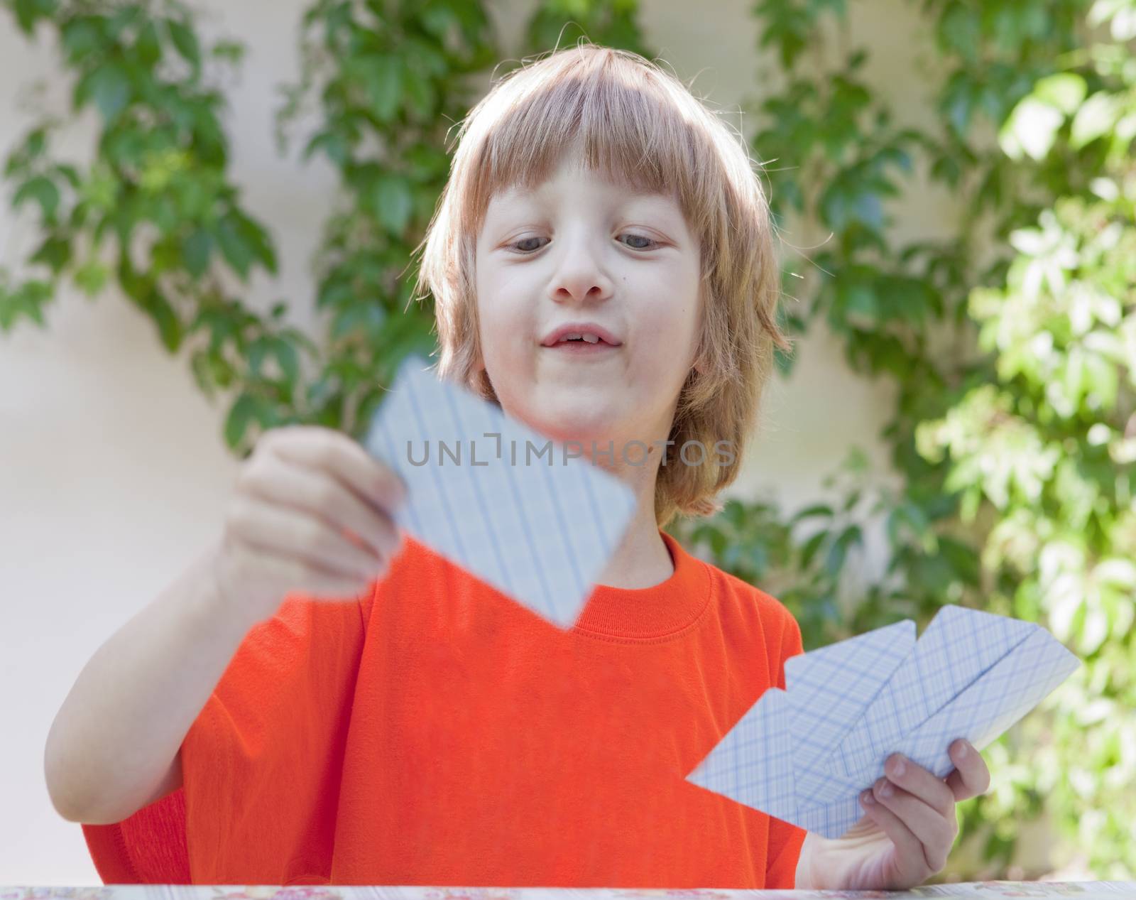 Boy with Blond Hair Playing Cards Outdoors