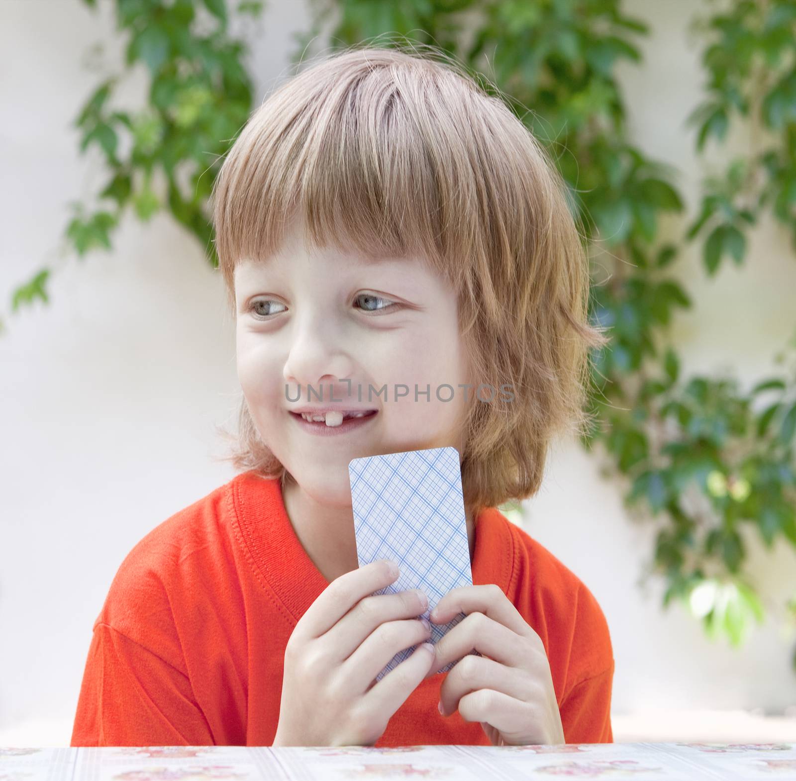 Boy with Blond Hair Playing Cards Outdoors