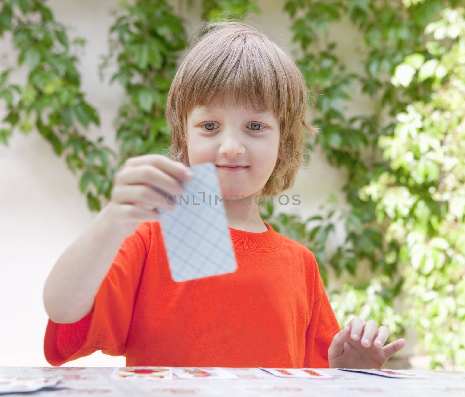 Boy with Blond Hair Playing Cards by courtyardpix