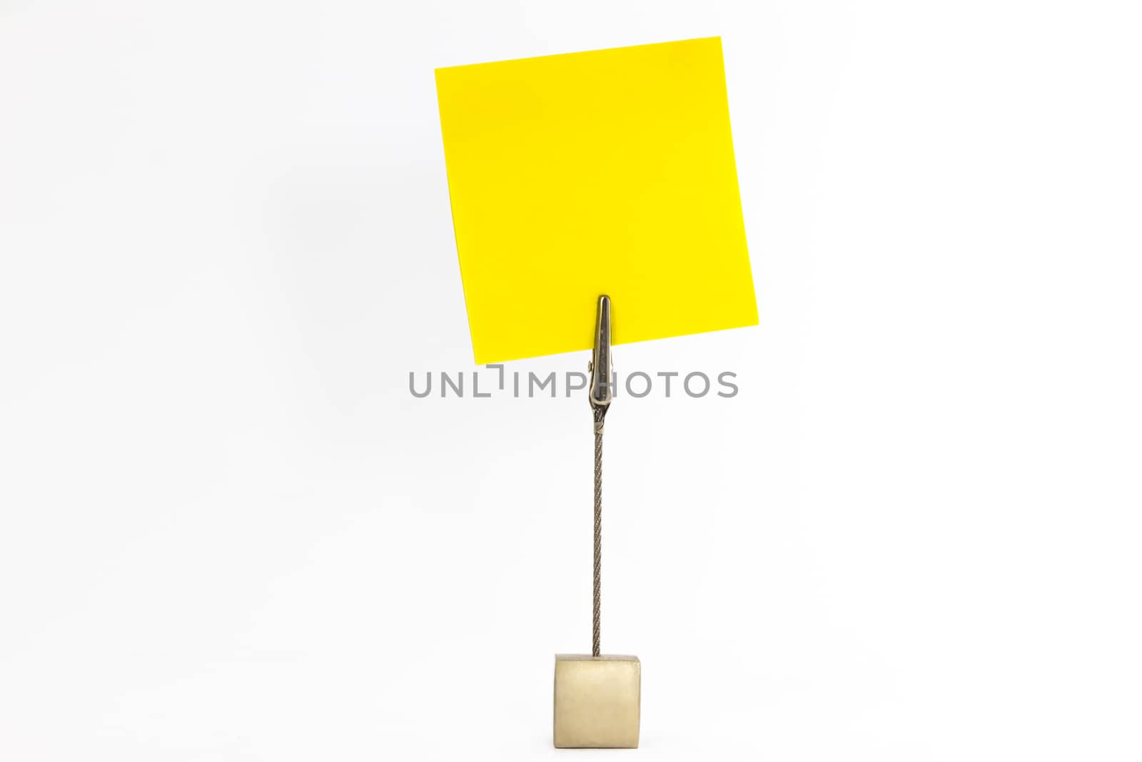 Paperclip holds empty yellow sticky note