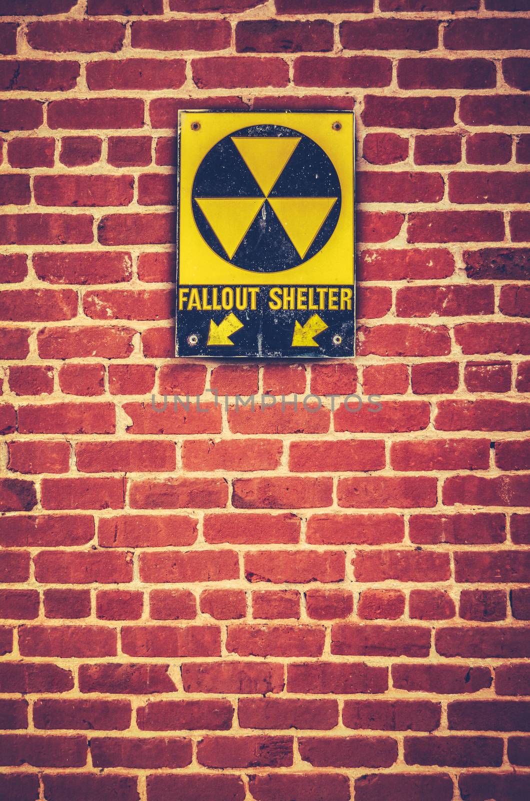 Retro Styled Nuclear Fallout Shelter Sign On A Red brick Wall