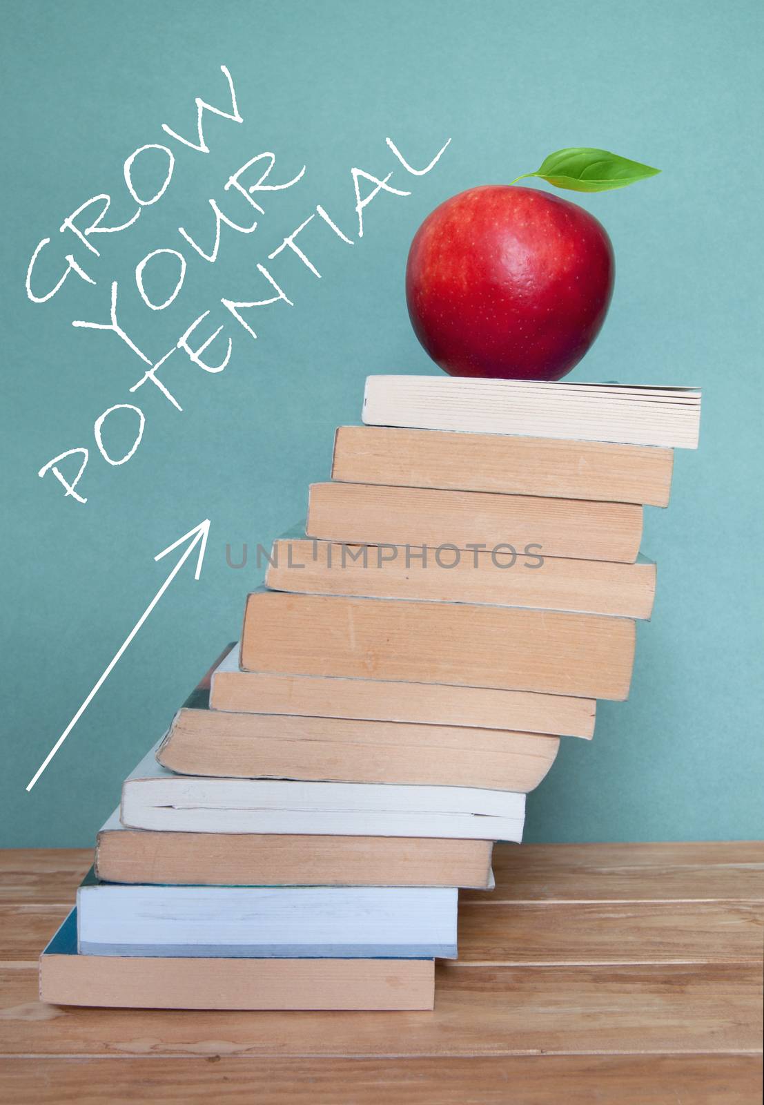 Personal development and progress in education concept with large pile of books and arrow pointing upwards 