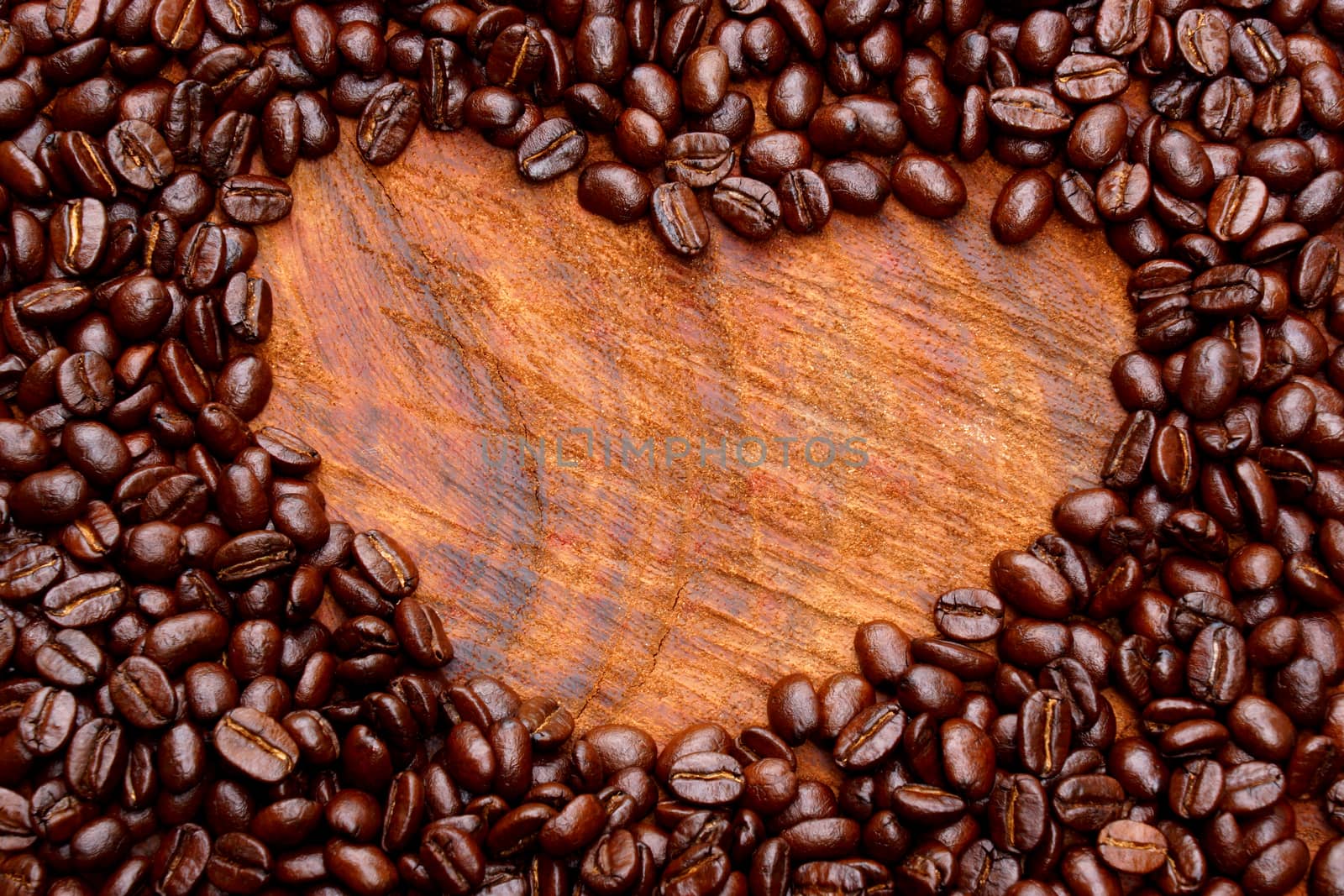 Coffee beans on the wooden background.