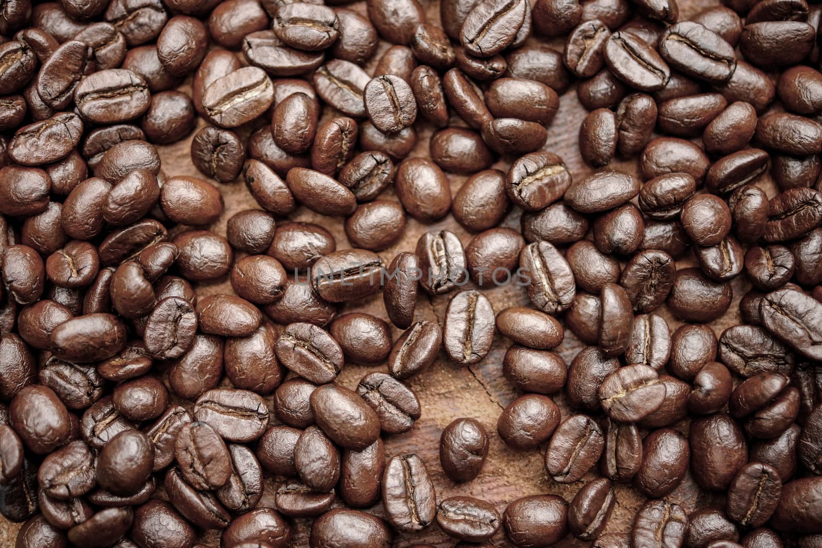 Coffee beans on the wooden background.