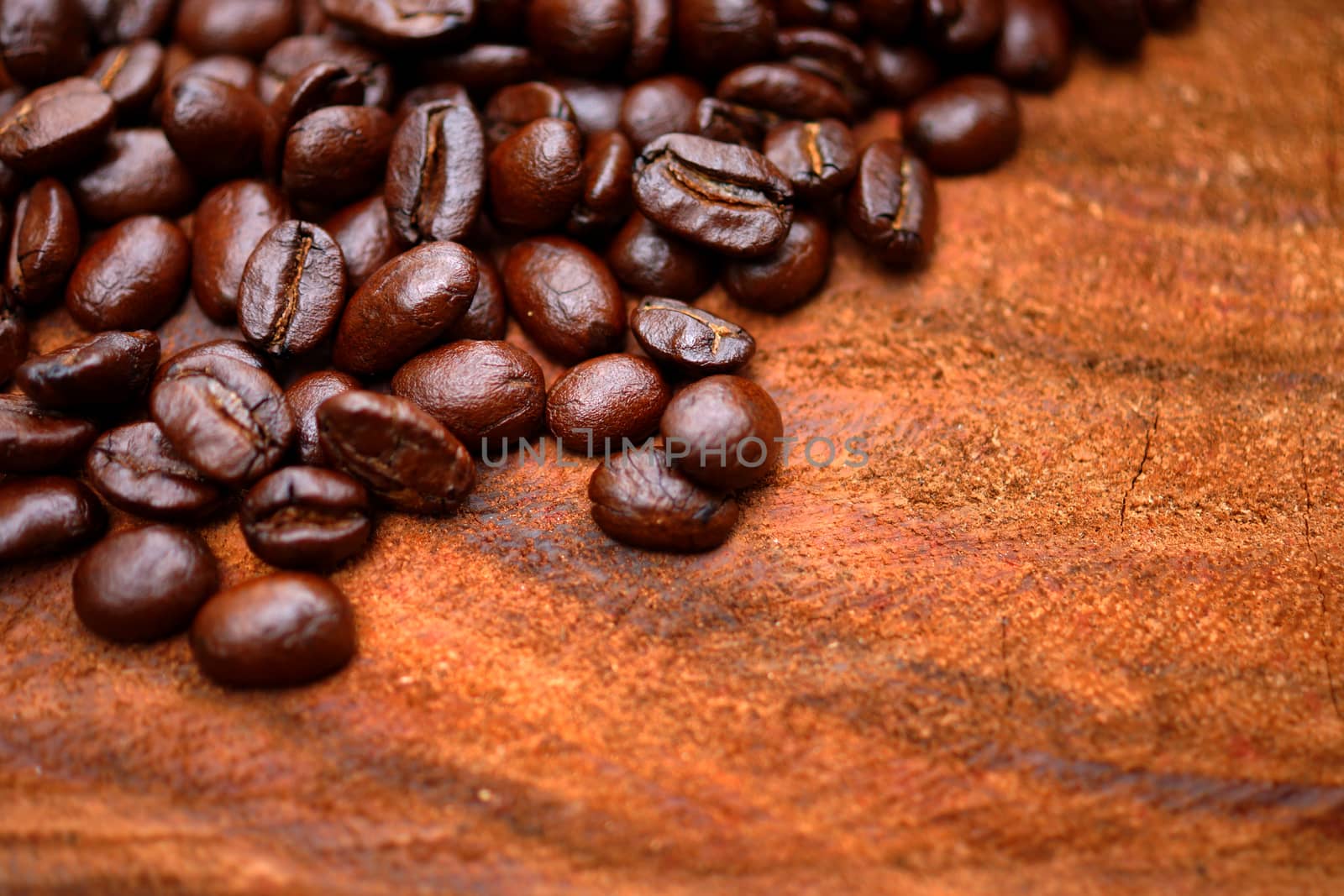 Coffee beans on the wooden background.