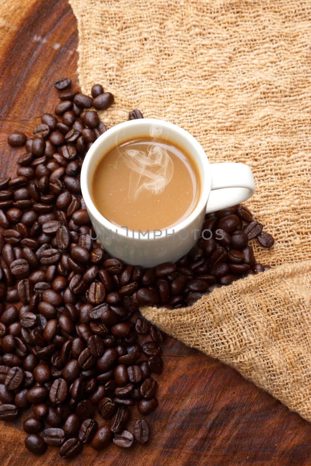 Coffee and beans on the wooden background.