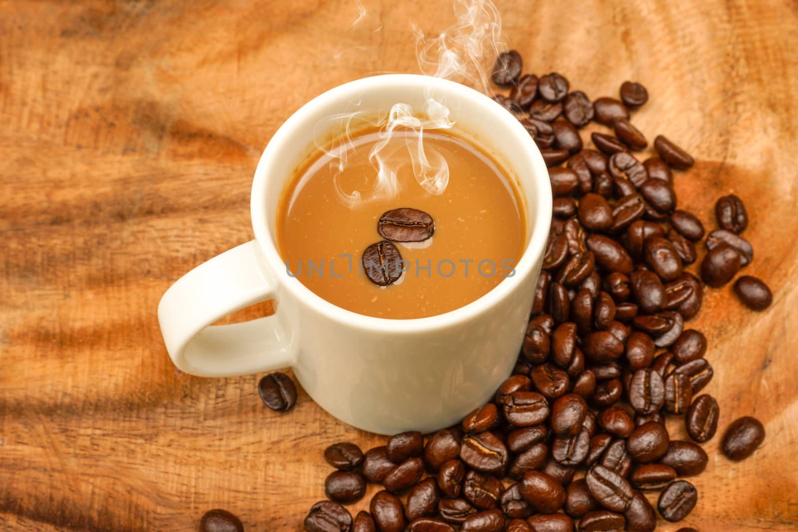 Coffee and beans on the wooden background.