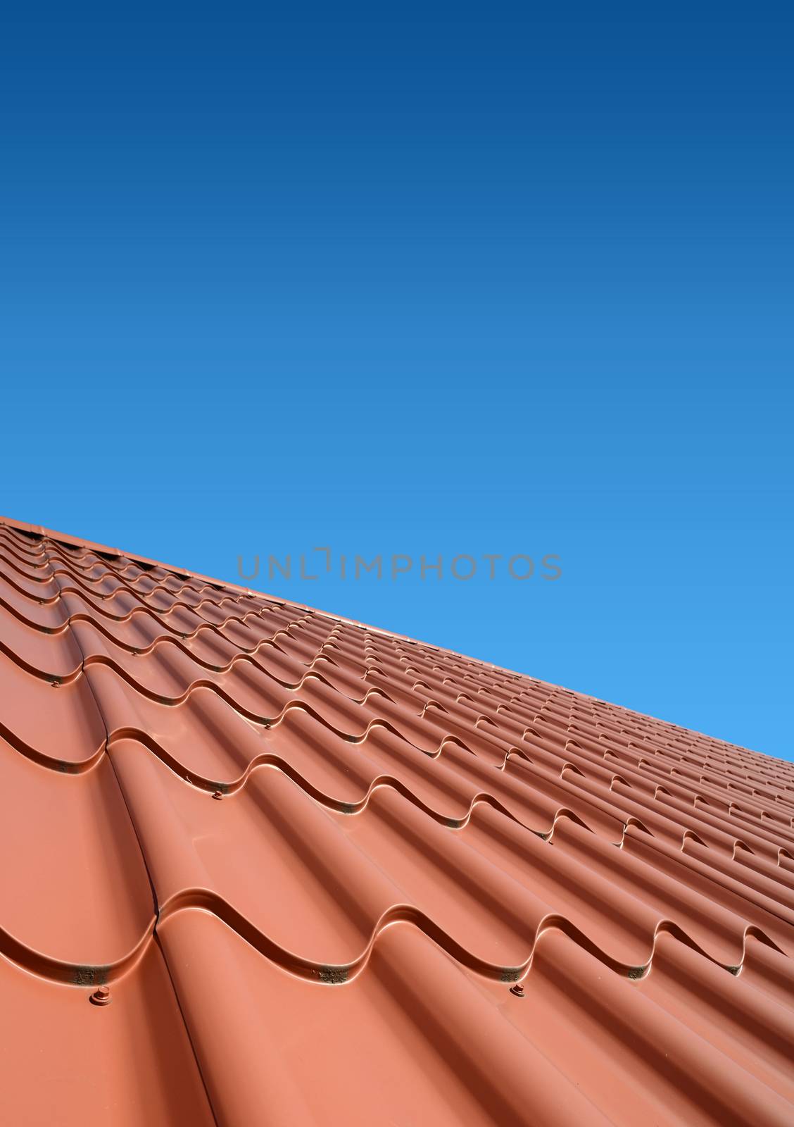 New roof with orange sheet metal and background of blue sky