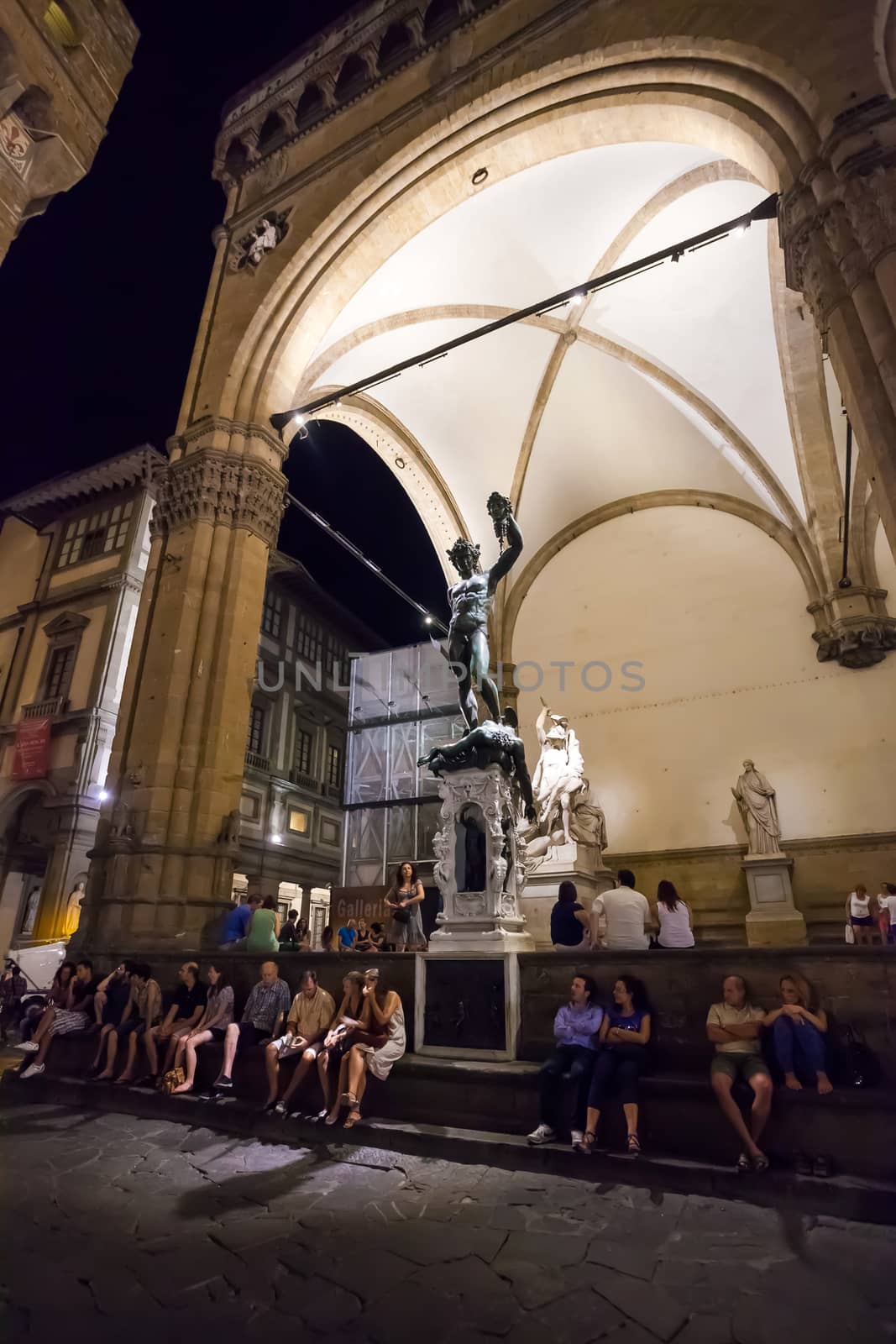 Pisa, Italy - August 10, 2013: Tourists arround Perseus holding head of Medusa, bronze statue by Benvenuto Cellini in Loggia de Lanzi, Piazza della Signoria, Florence, Italy