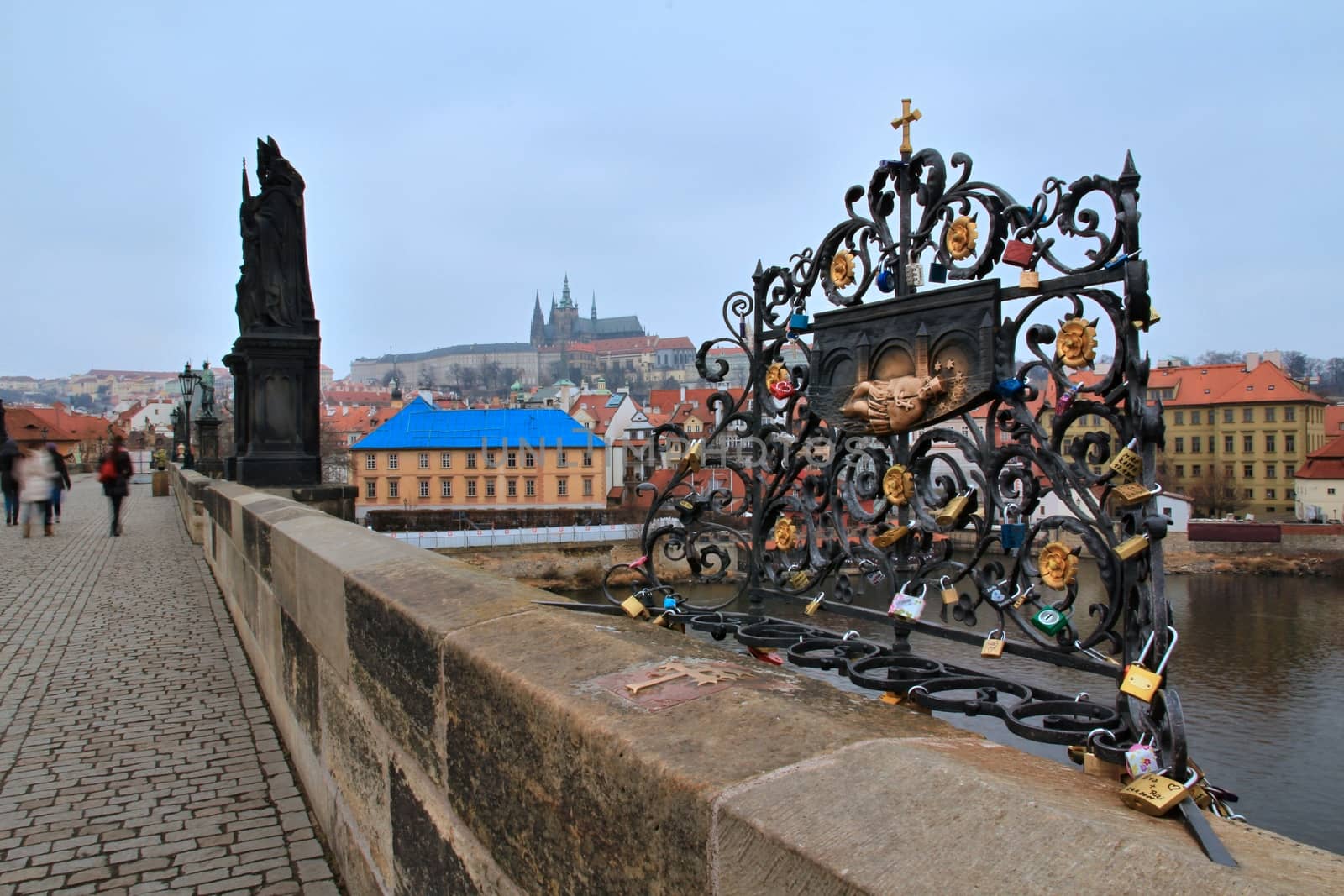 Photo of Charles bridge in Prague, Czech republic with the view onto love locks, old houses, towers and Vltava river.