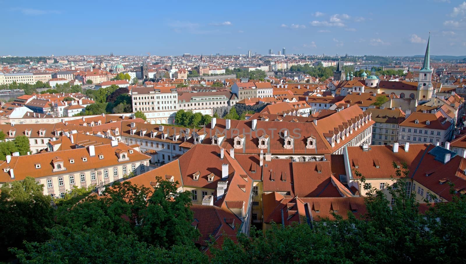 Photo shows general view onto city red roof houses.