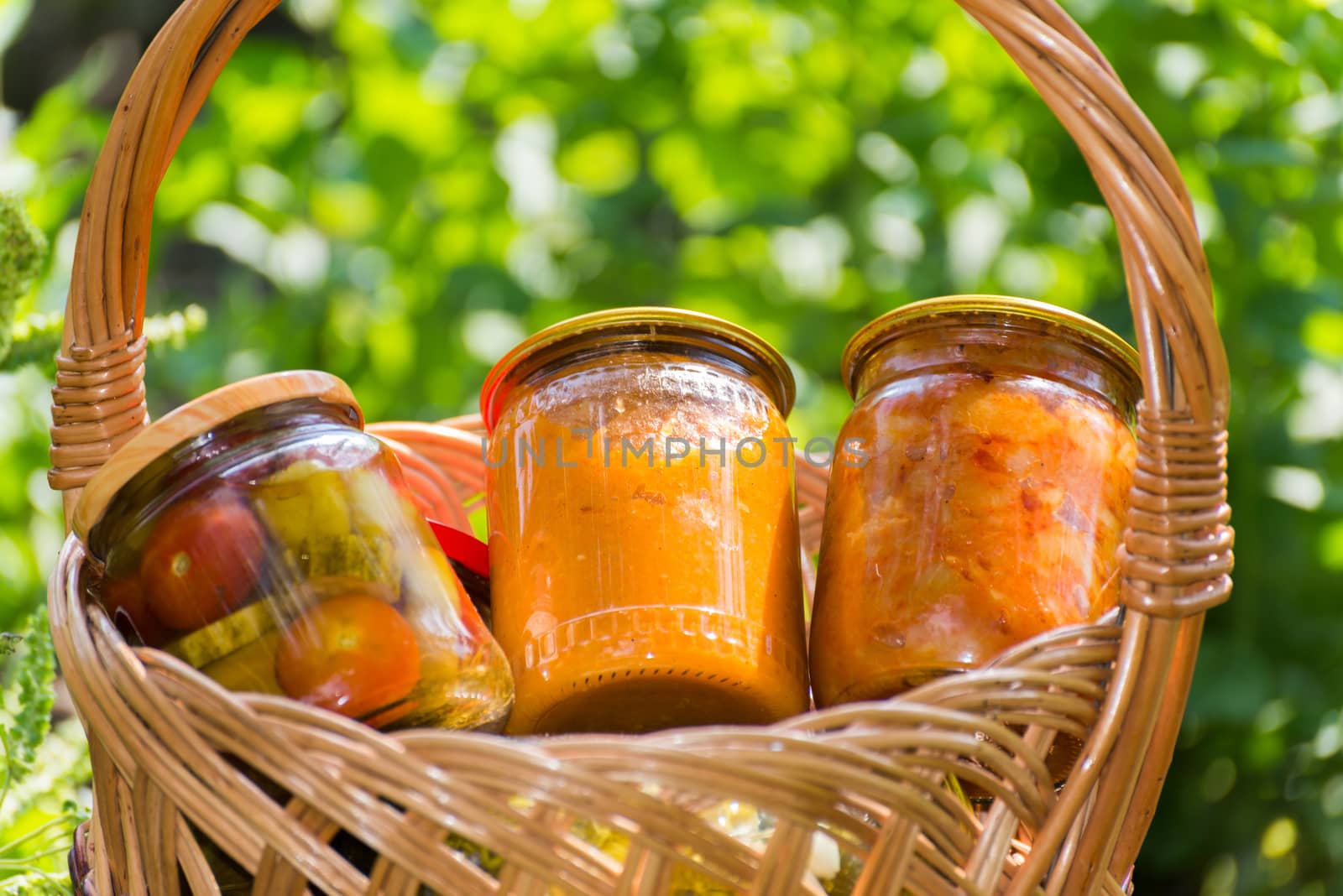 Canned vegetables homemade in wicker basket by olgavolodina