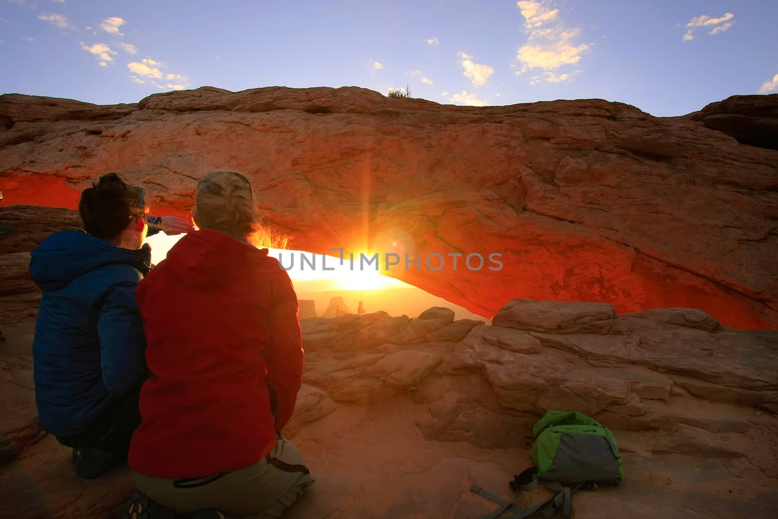 Tourists watching sunrise at Mesa Arch, Canyonlands National Par by donya_nedomam