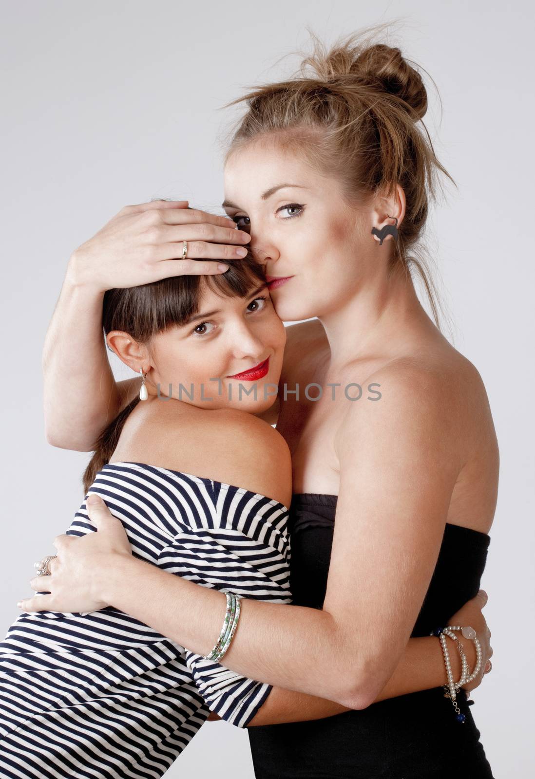 Two Young Female Friends Embracing - Isolated on Gray