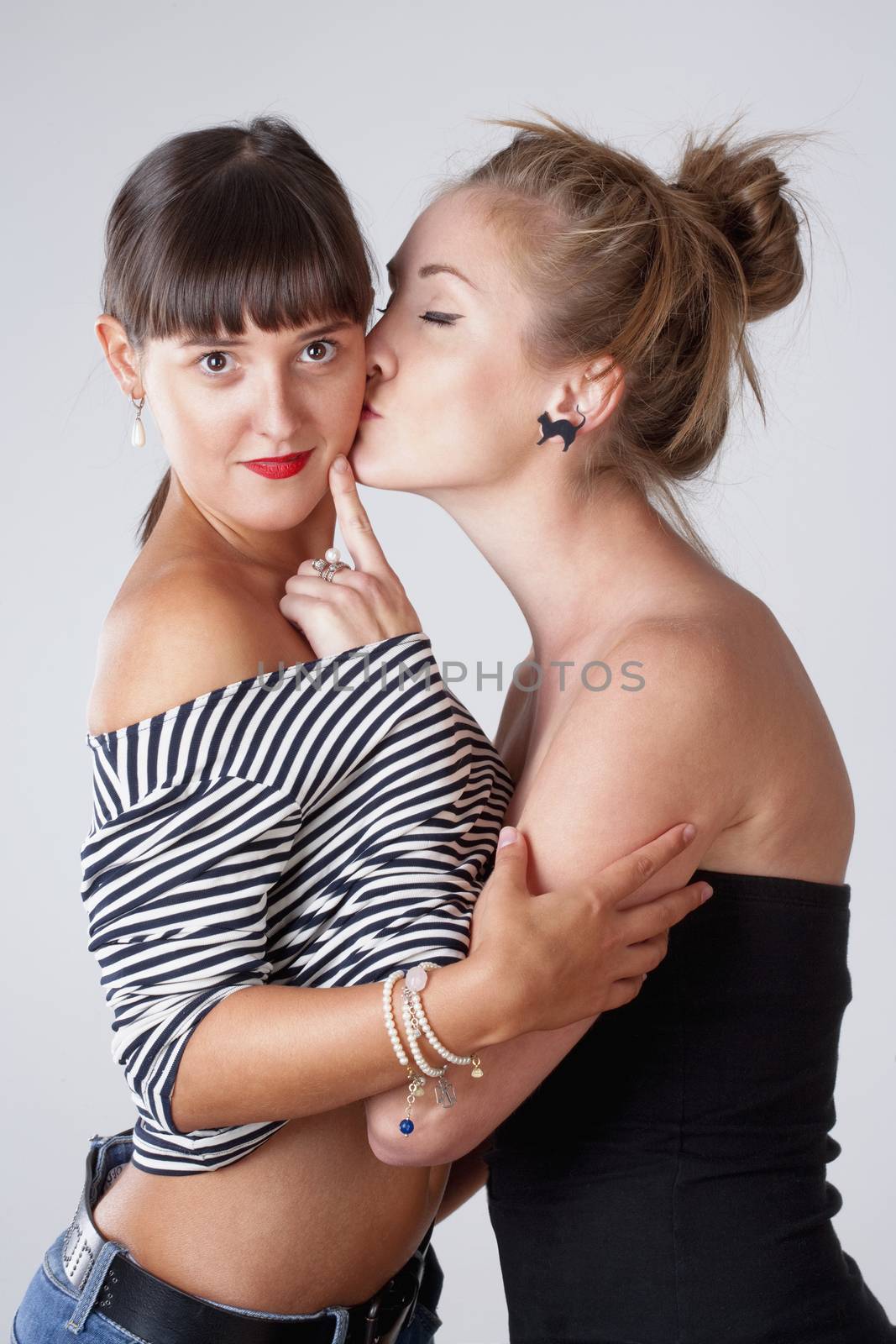 Two Young Female Friends Embracing - Isolated on Gray