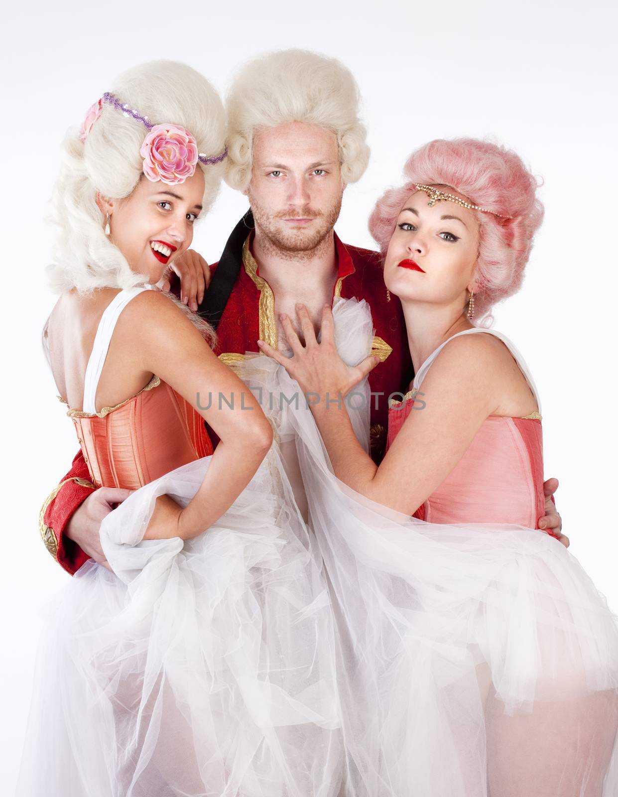 Two Young Female Friends in Historical Costumes Embracing a Man