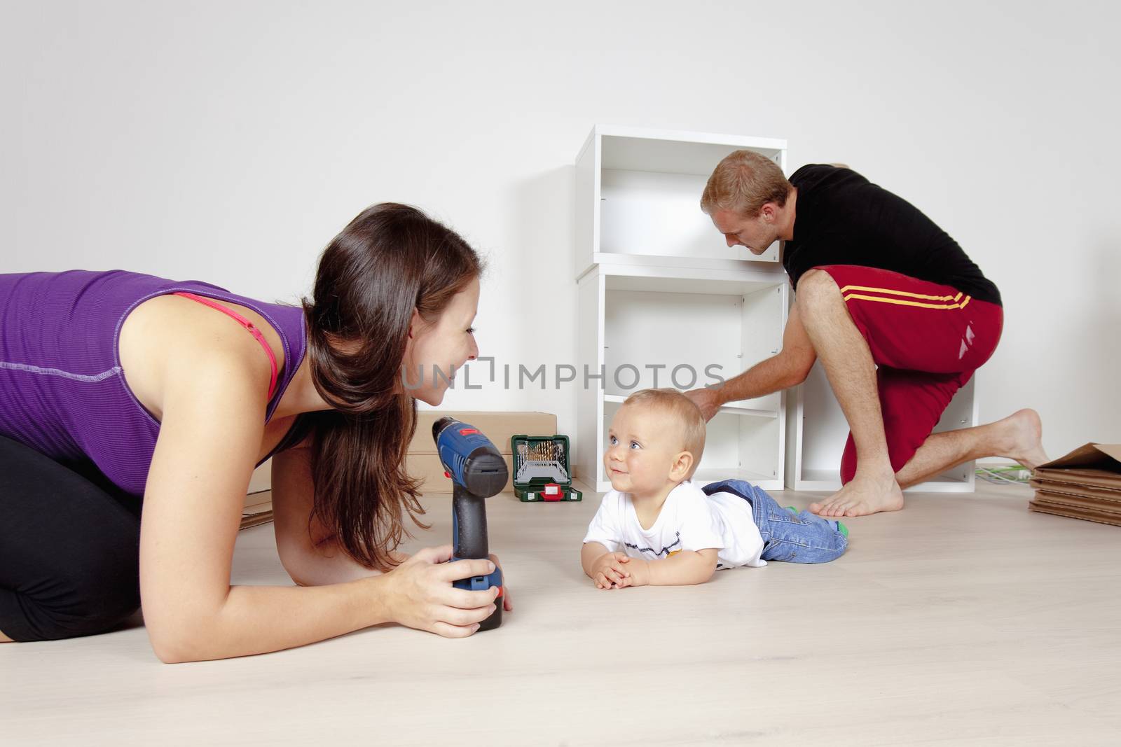 Young Family with a Baby Moving in a New Apartment