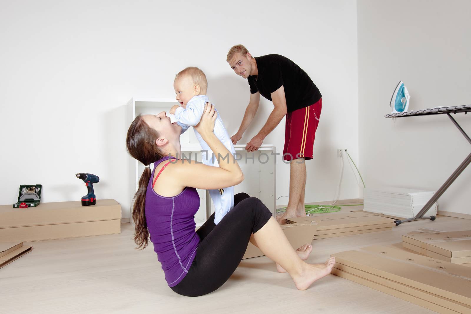 Young Family with a Baby Moving in a New Apartment