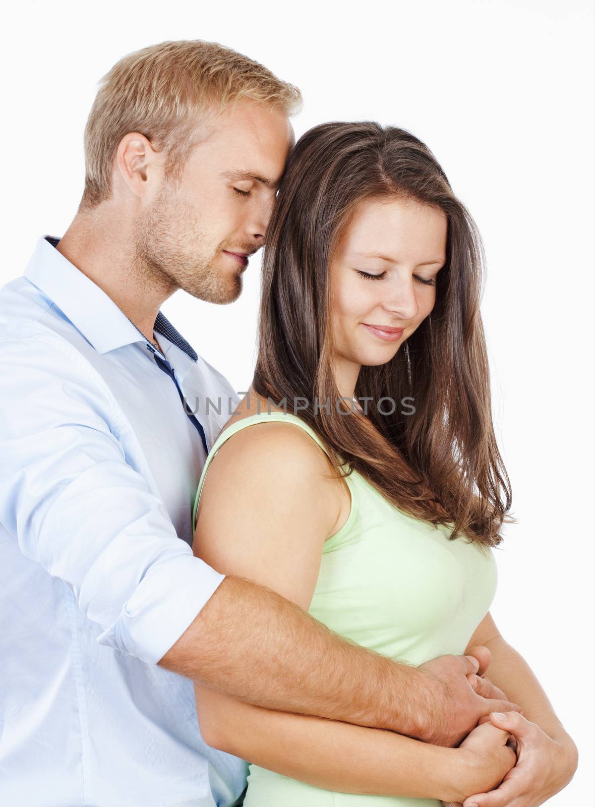 Portrait of a Happy Young Couple Embracing by courtyardpix