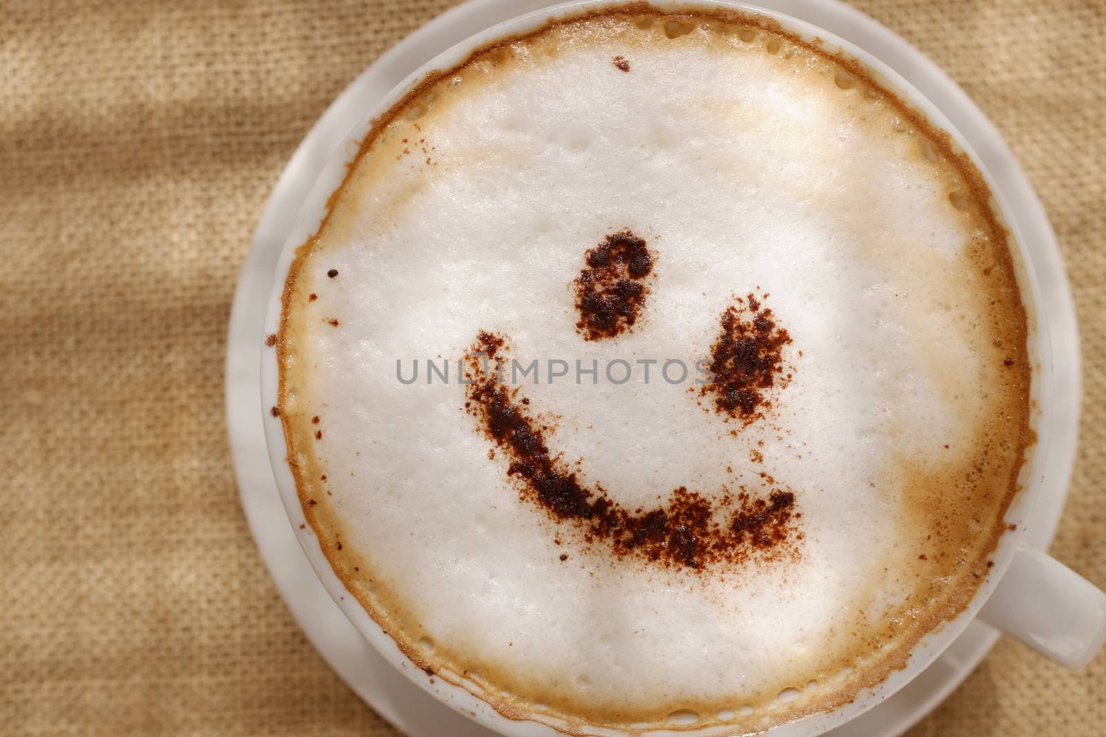 Coffee cappuccino with foam or chocolate smiling welcome happy face in restaurant or hotel