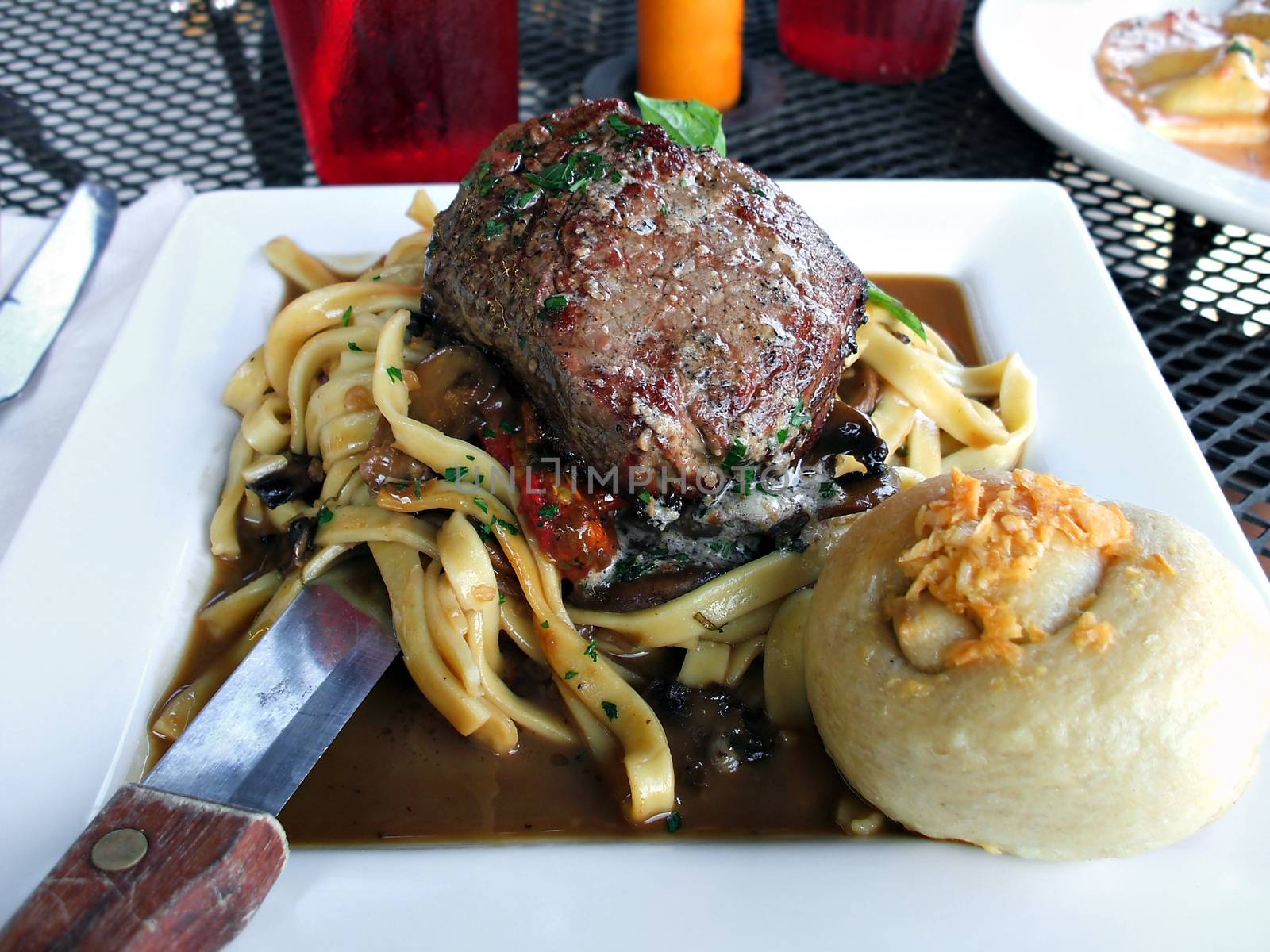 Petite filet mignon on a bed of homemage pasta with mushrooms and truffle oil.  Shallow depth of field. 