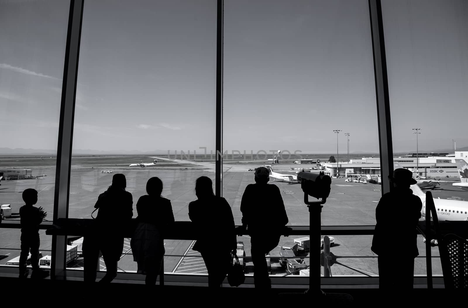 Vancouver, BC Canada - September 13, 2014 : People inside YVR airport watching air canada airplane in Vancouver BC Canada. 