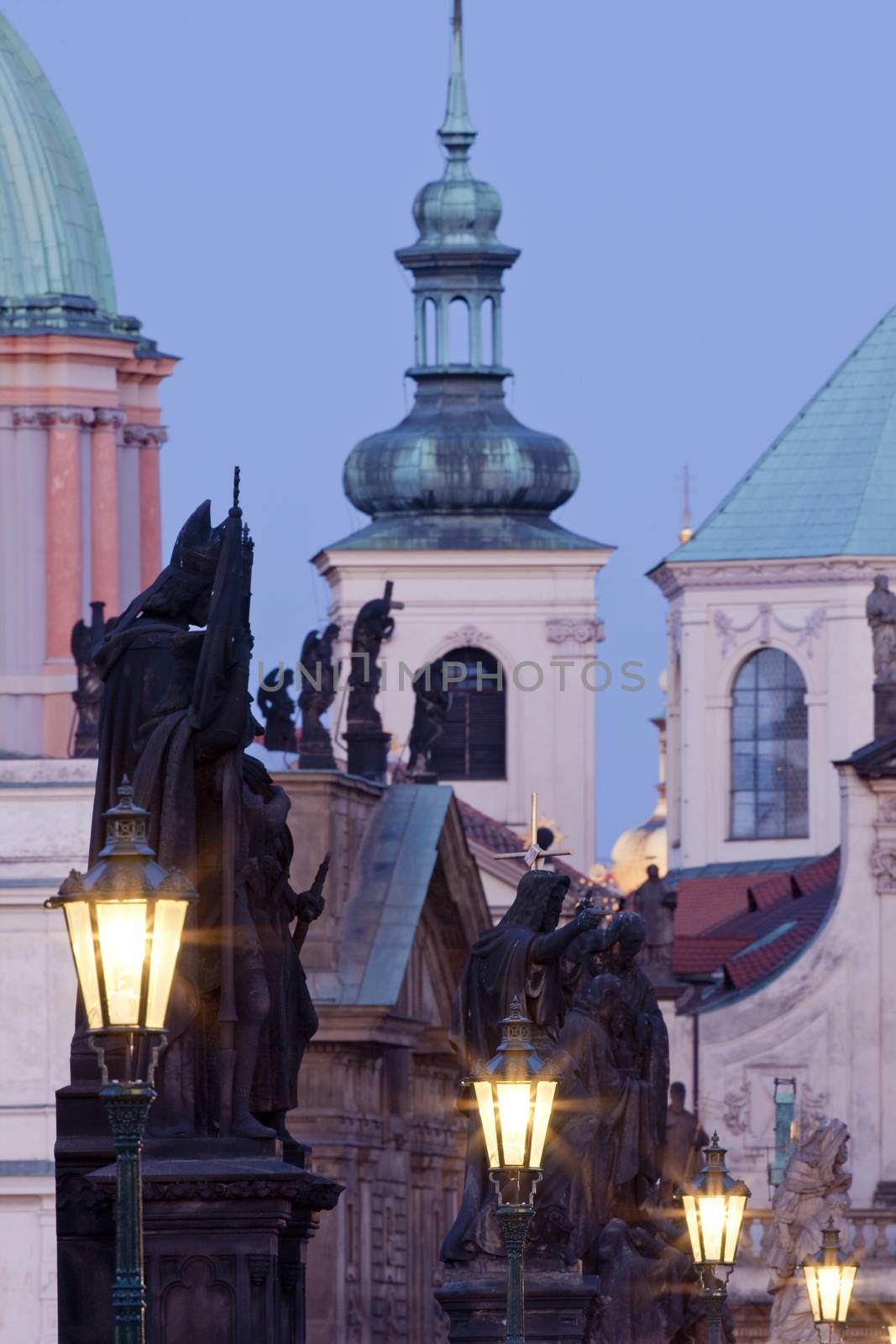 prague - religious art on charles bridge, lanterns and spires of the old town