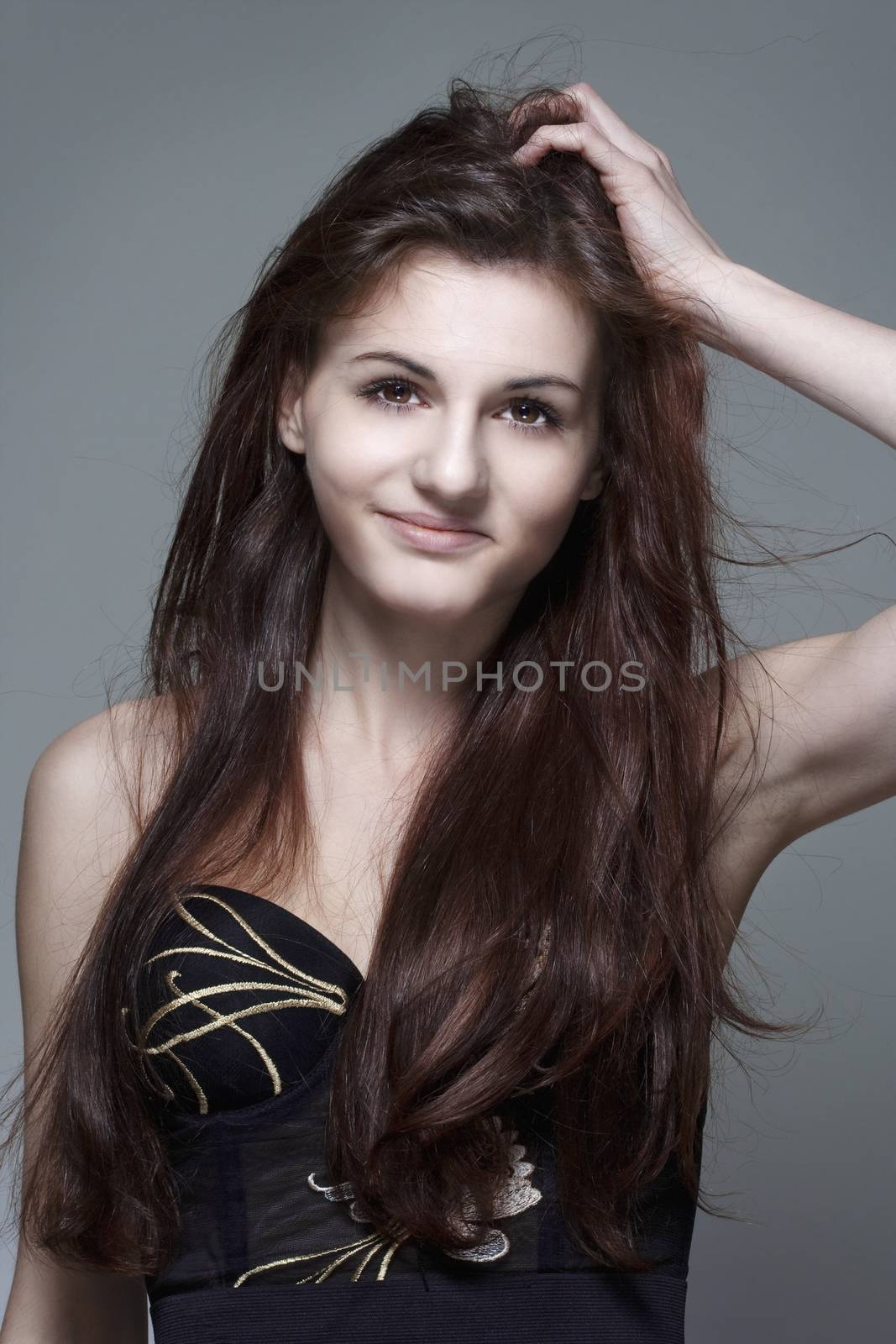 portrait of a young girl with long brown hair - isolated on gray