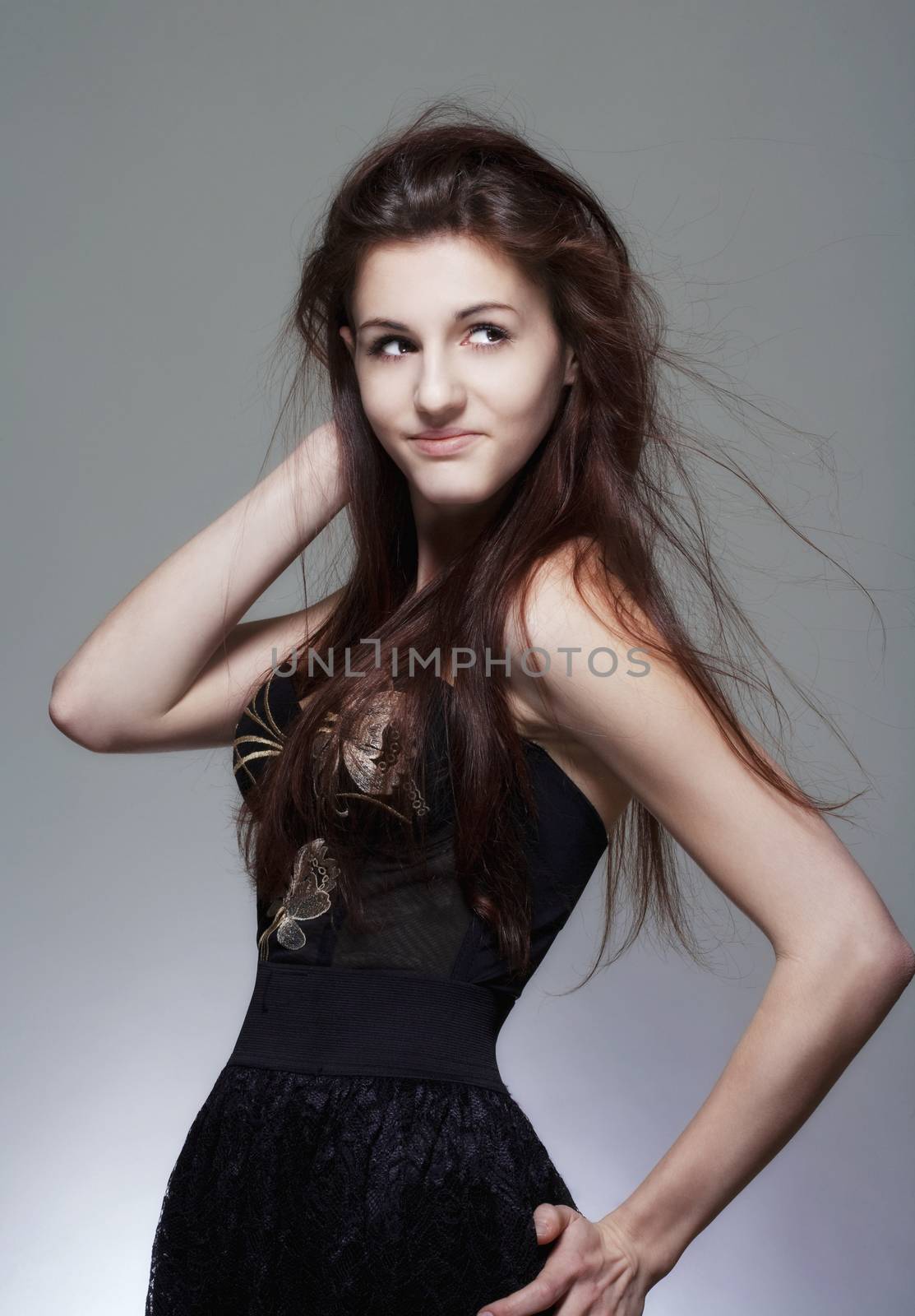 portrait of a young girl with long brown hair - isolated on gray