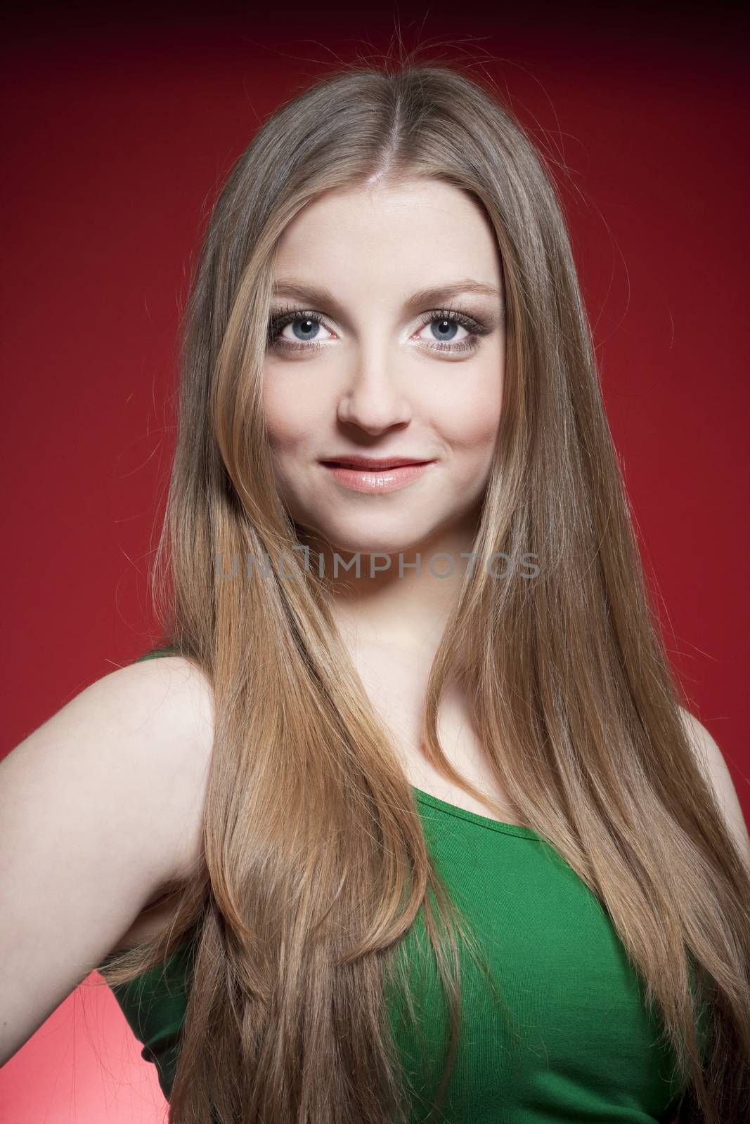 portrait of a young beautiful woman with brown hair against red background