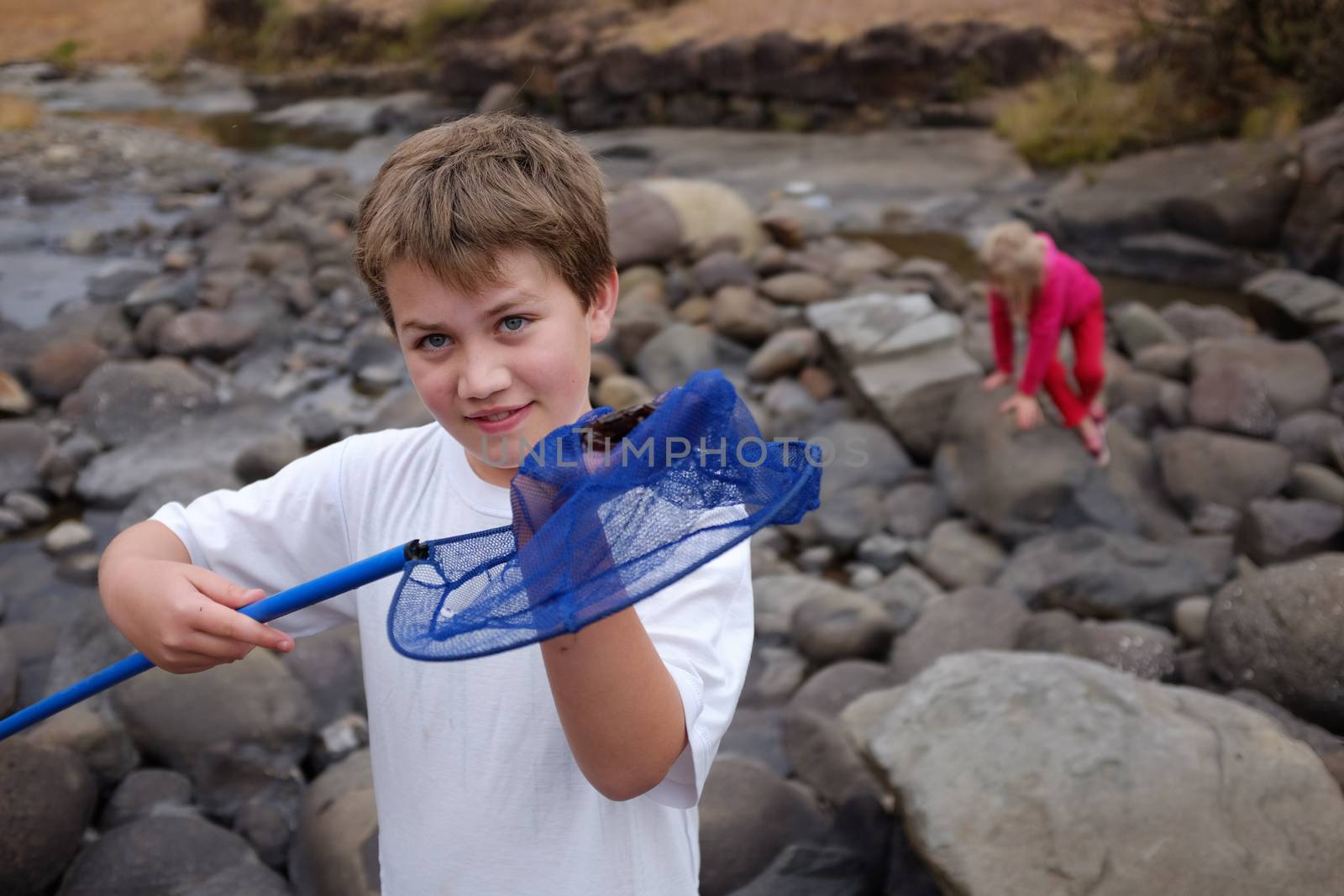 Vacation boy catching crab at river by alistaircotton