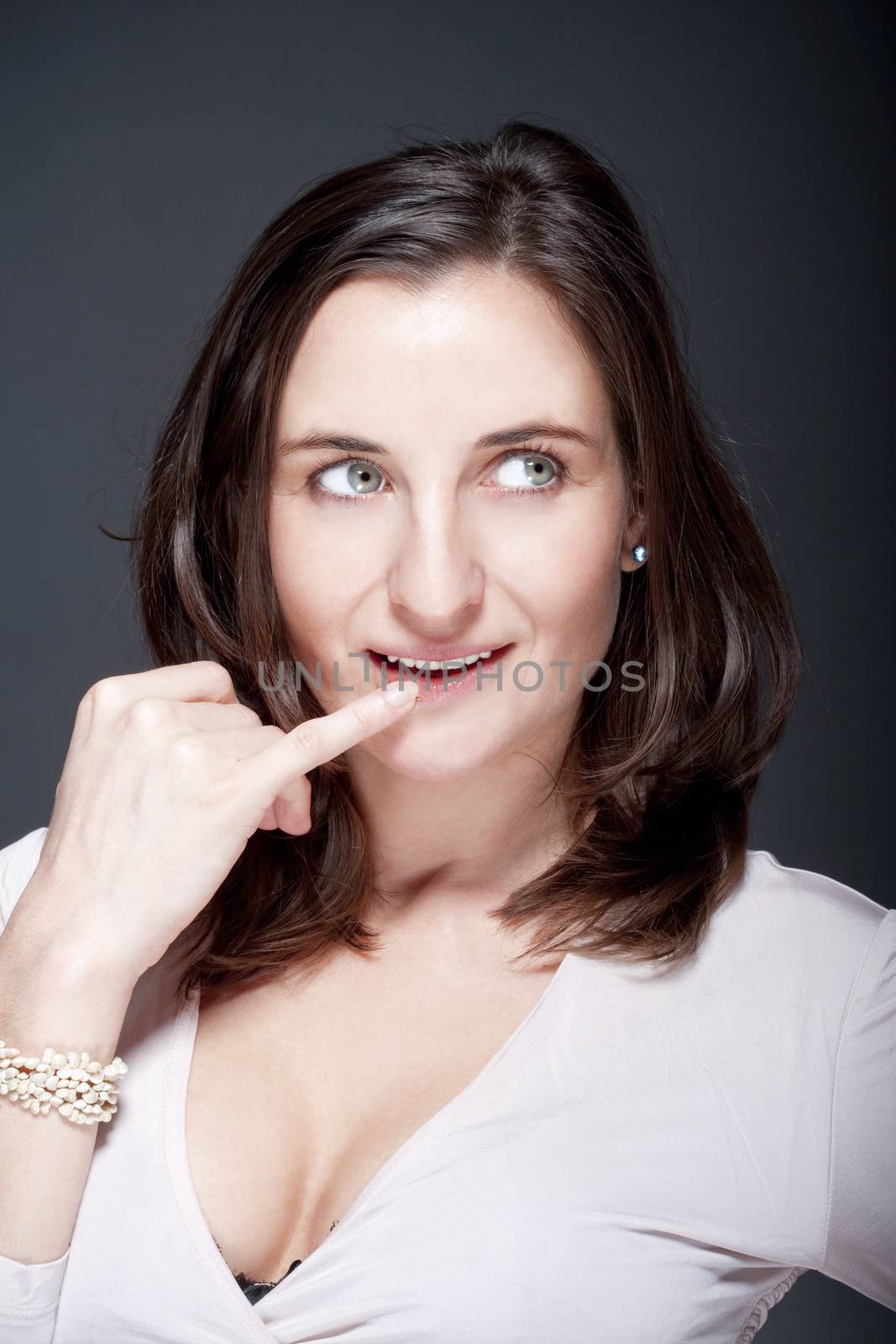 portrait of beautiful woman with brown hair looking - gray background