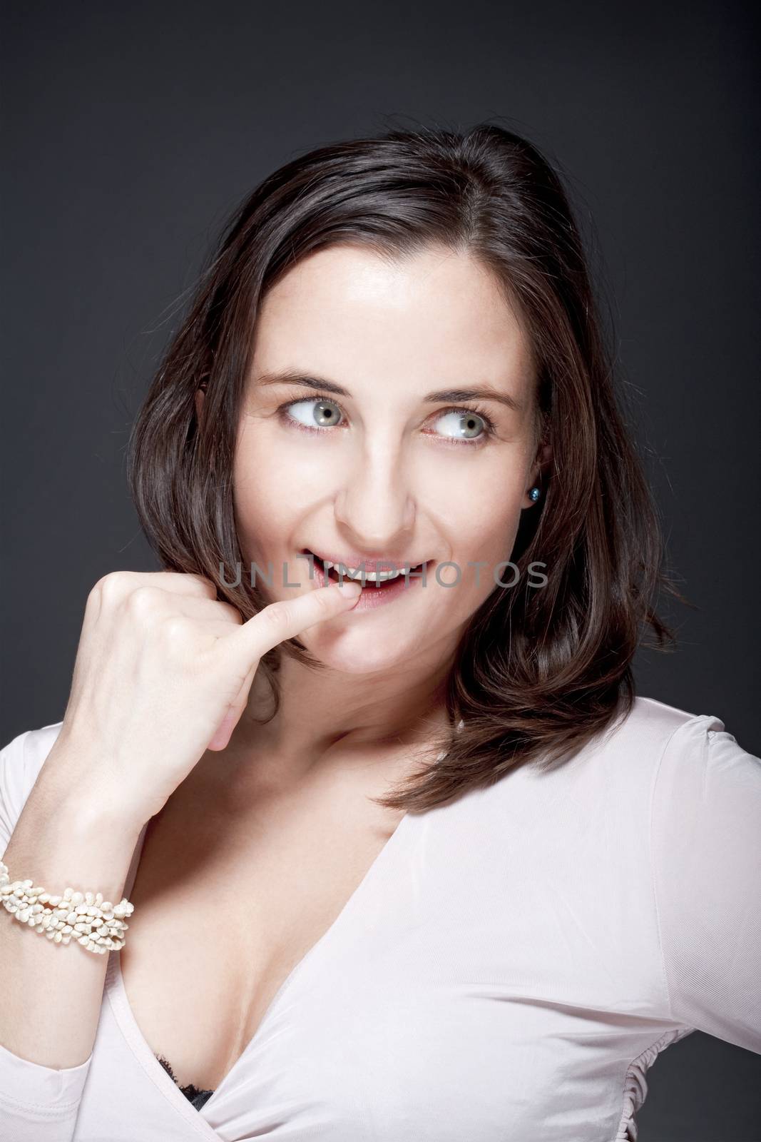 portrait of beautiful woman with brown hair looking - gray background