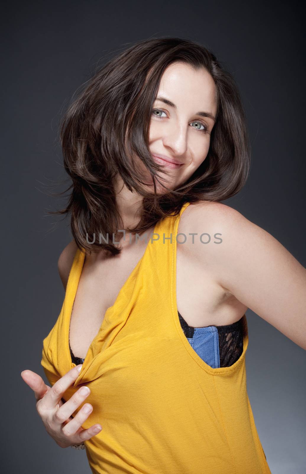 portrait of beautiful woman with brown hair smiling - gray background