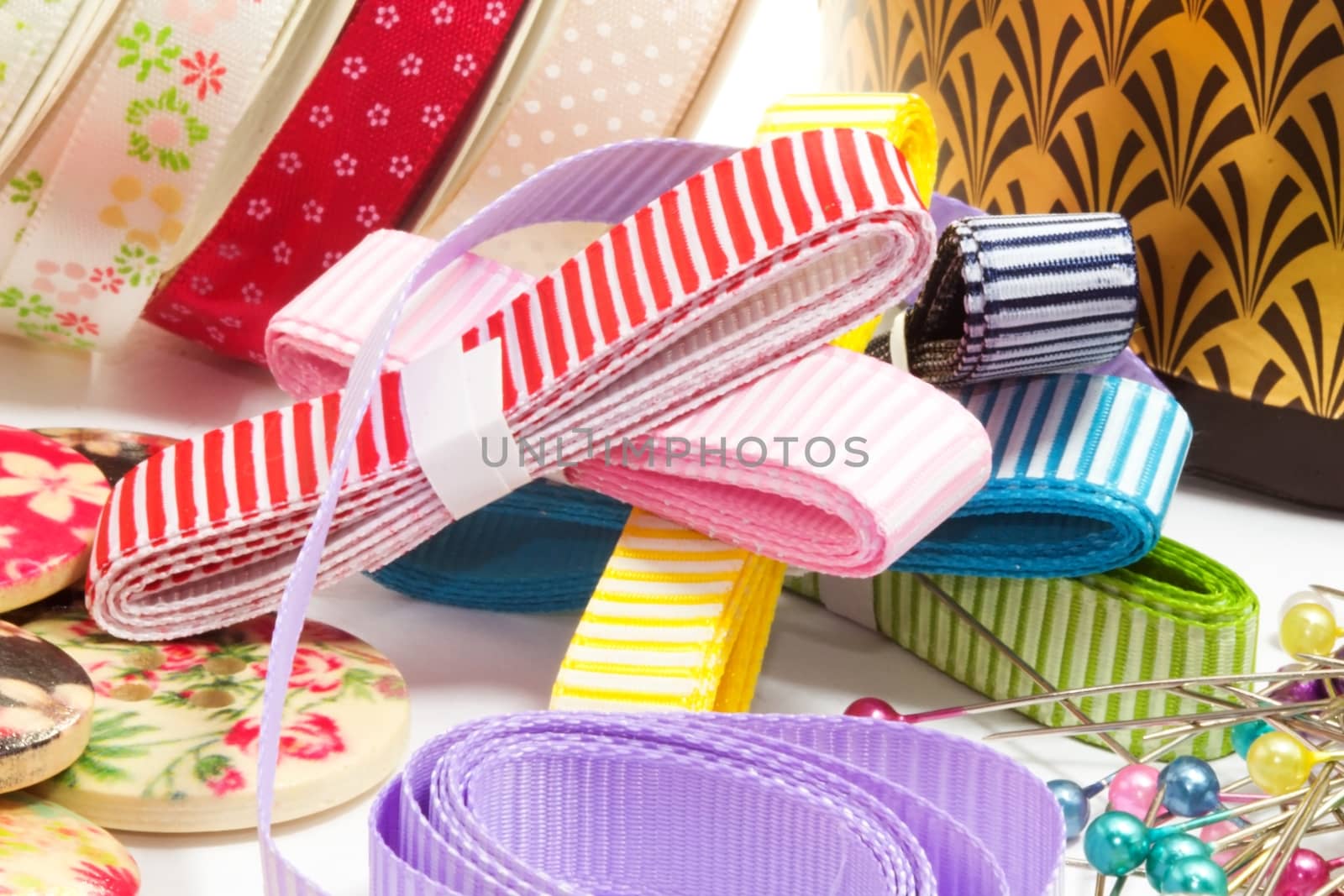 Photo presents various sewing accessories, including buttons, needles and bows.